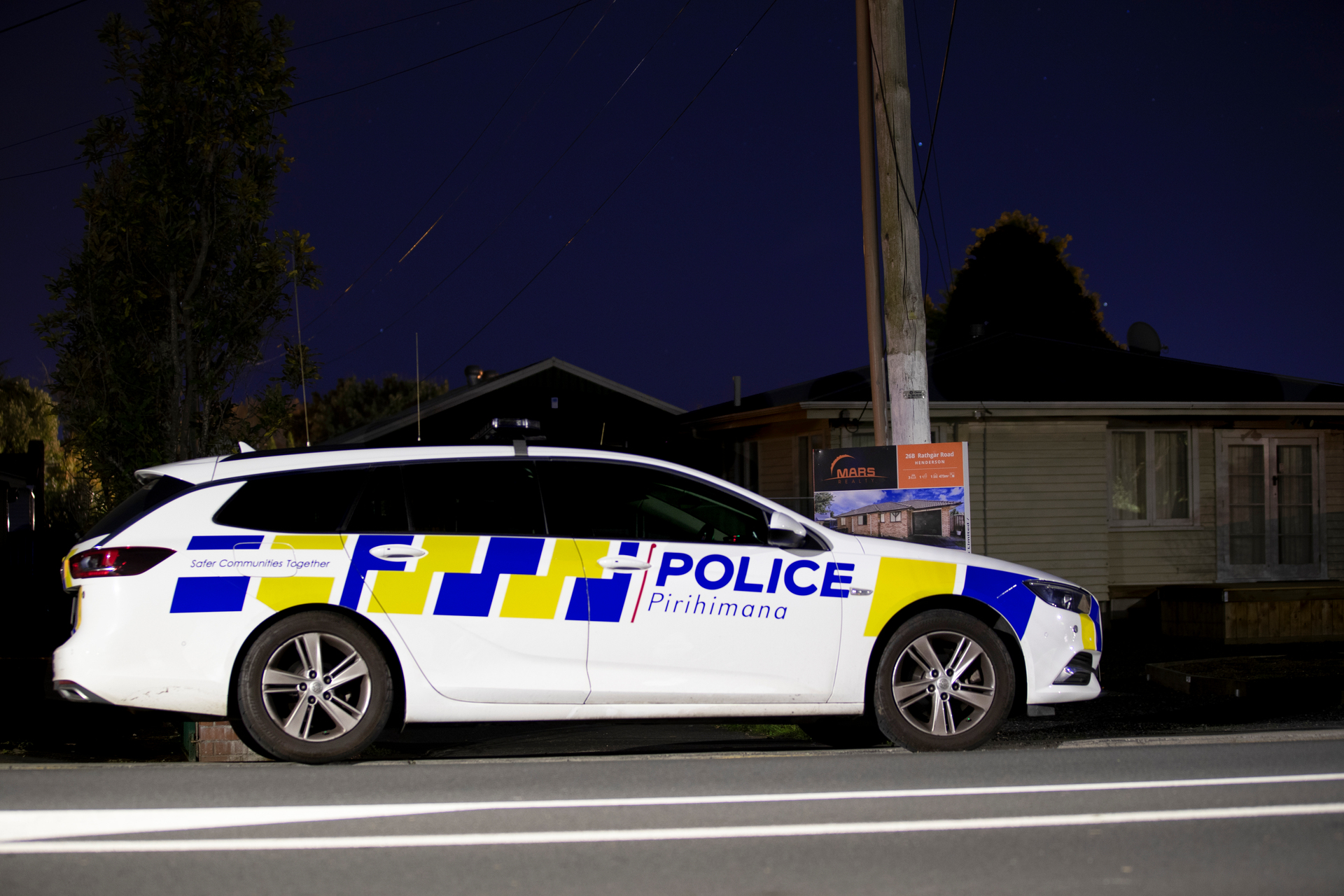 A police car outside a driveway on Rathgar Rd in Henderson, West Auckland, last night. Photo / Hayden Woodward