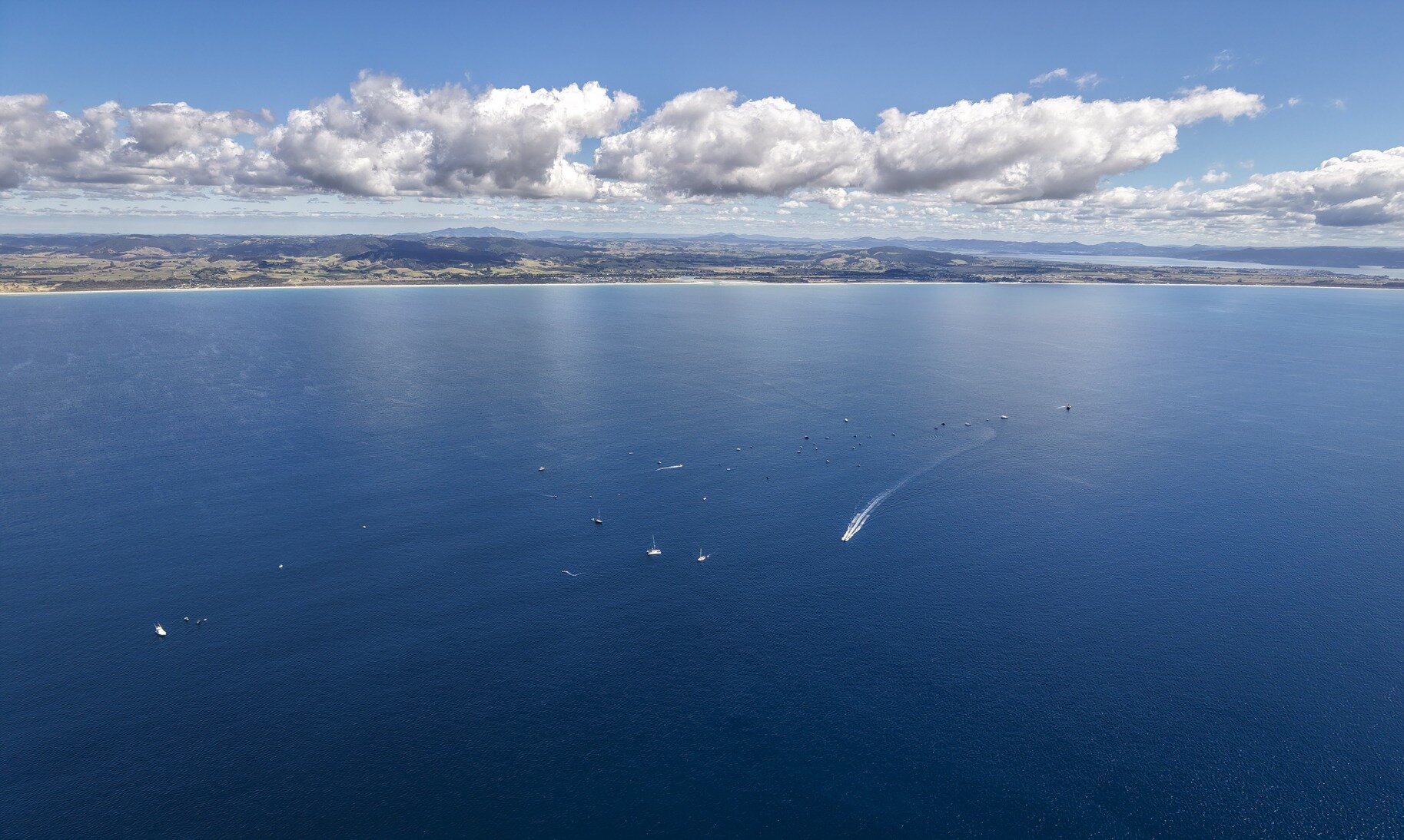 The boats hit the water where the sand mining will take place, about 5km offshore from Ruakaka Beach. Photo / Geoff Reid
