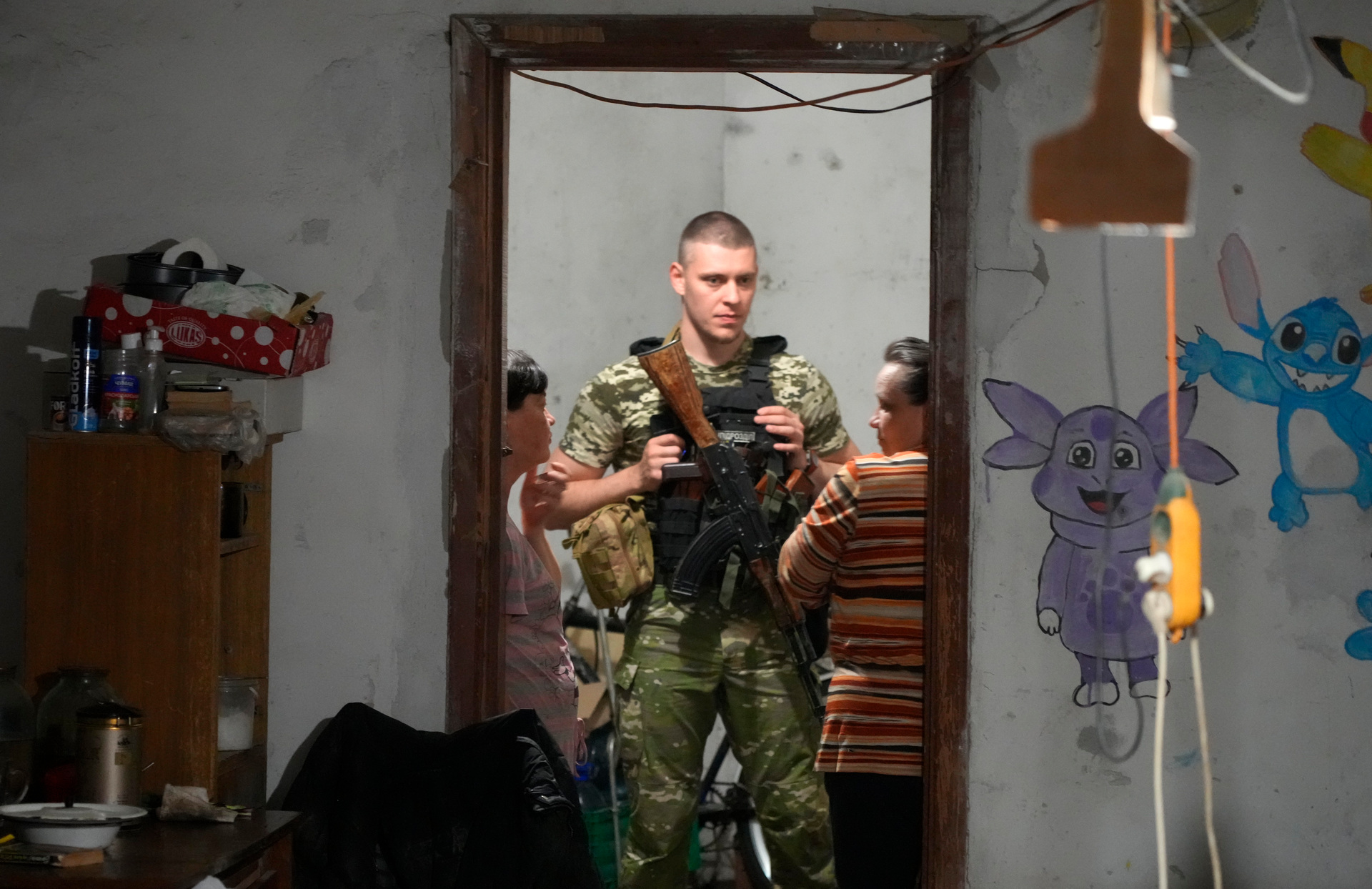 A Ukrainian soldier speaks with women in a basement in Lysychansk, Ukraine. Photo / AP