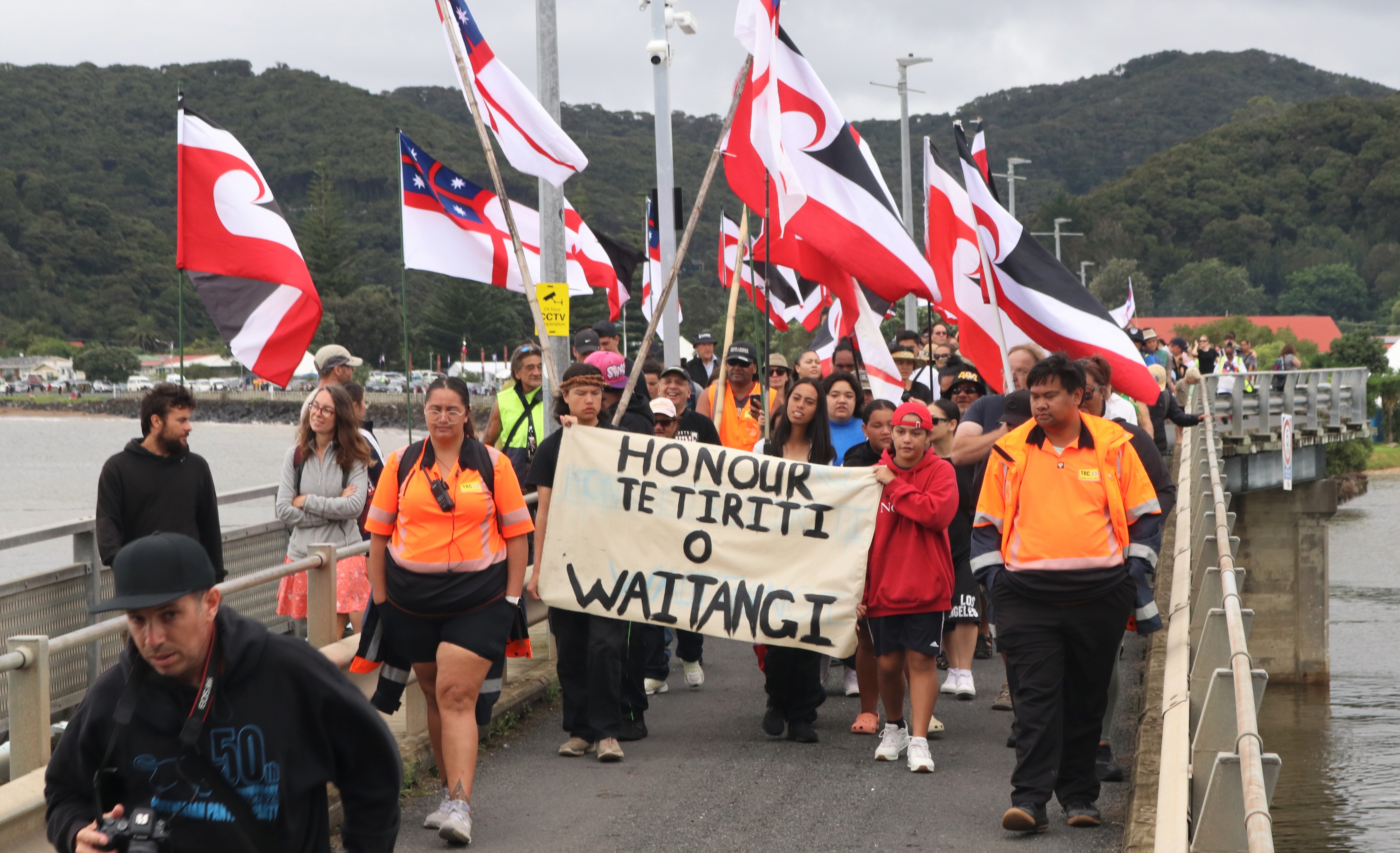 A hīkoi that left Te Rerenga Wairua [Cape Reinga] five days earlier swells to more than 100 people during the final stretch across Waitangi Bridge to the Treaty Grounds. Photo / Peter de Graaf