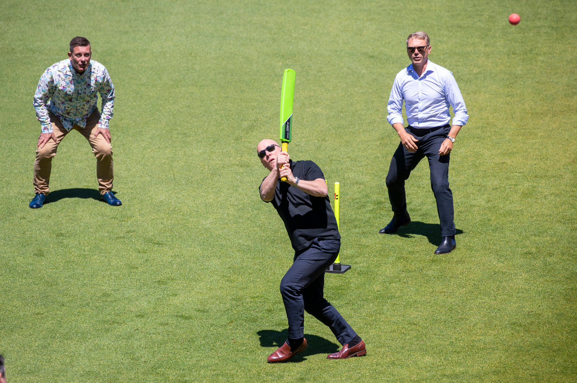 Christopher Luxon hits a ball high into the stands at a National caucus retreat at the Basin Reserve in Wellington, watched by Michael Woodhouse, left, and Paul Goldsmith. Photo / Mark Mitchell