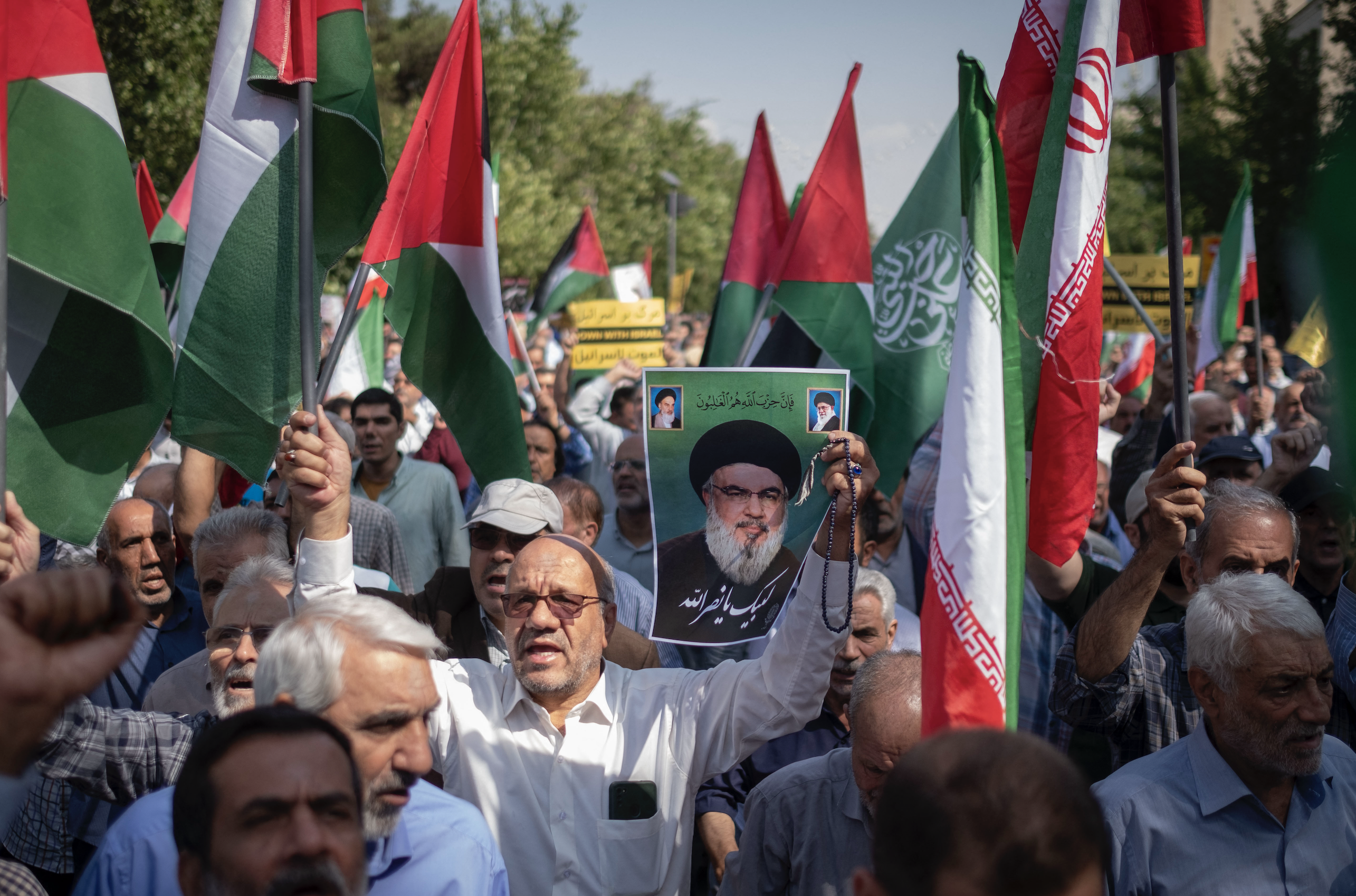 An Iranian worshipper carries a portrait of Lebanon's Hezbollah Secretary General, Hassan Nasrallah, during an anti-Israeli protest. Photo / AFP