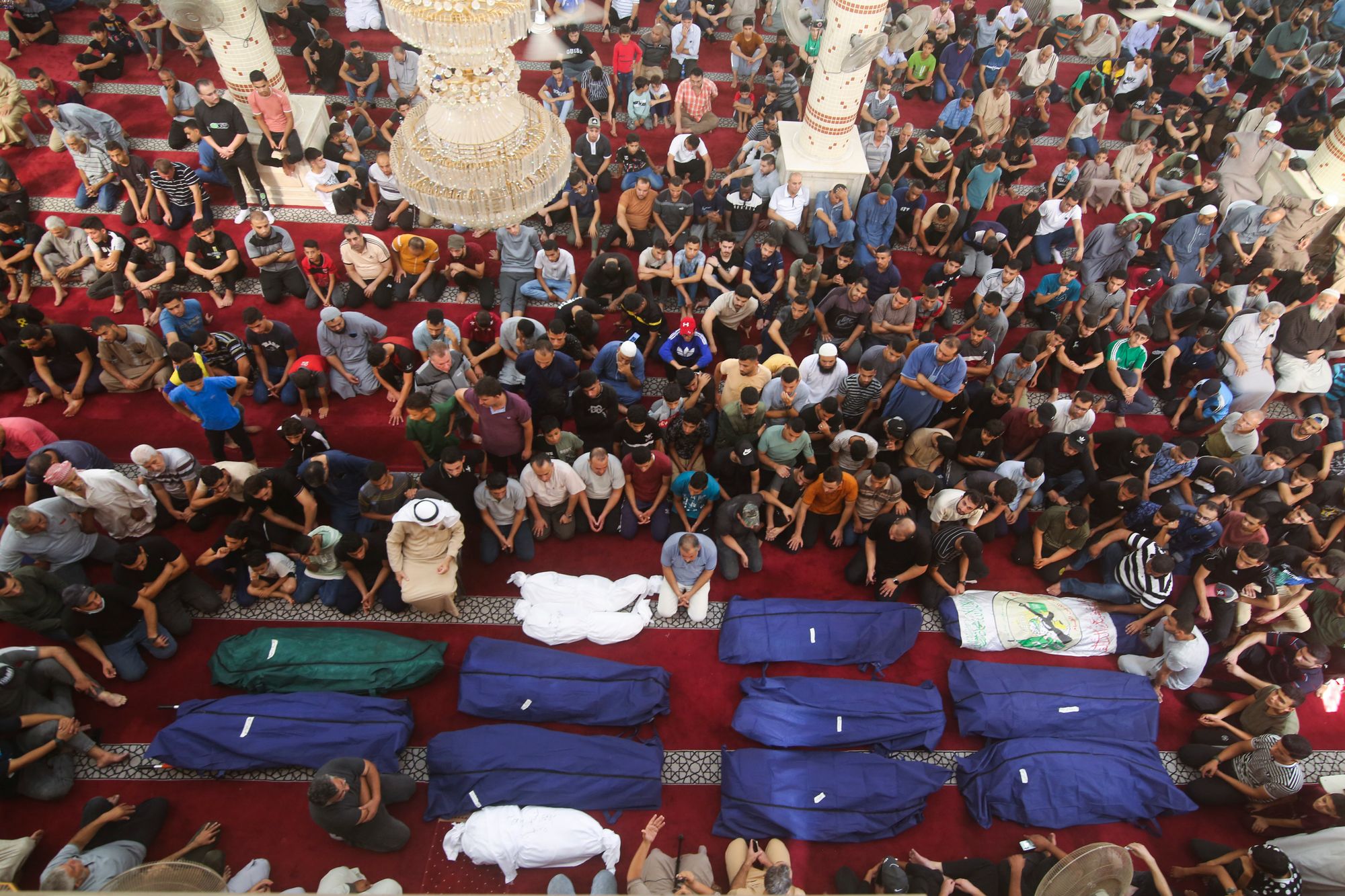 Mourners pray by the bodies of Salem Abu Quta family members, a Hamas fighter, during a funeral after they were killed in an Israeli strike on their house in Rafah refugee camp on Sunday. Photo / AP