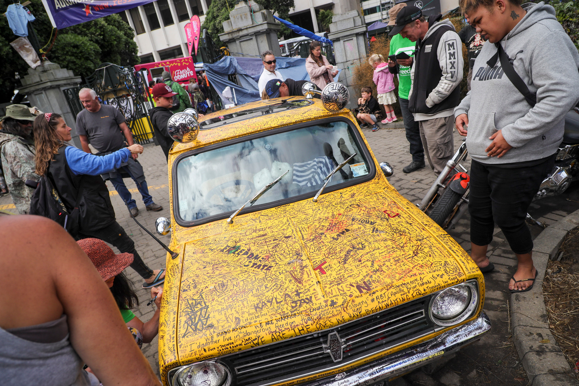 A yellow car parked on the Parliament grounds is covered by written messages by protesters.Photo / Mike Scott 