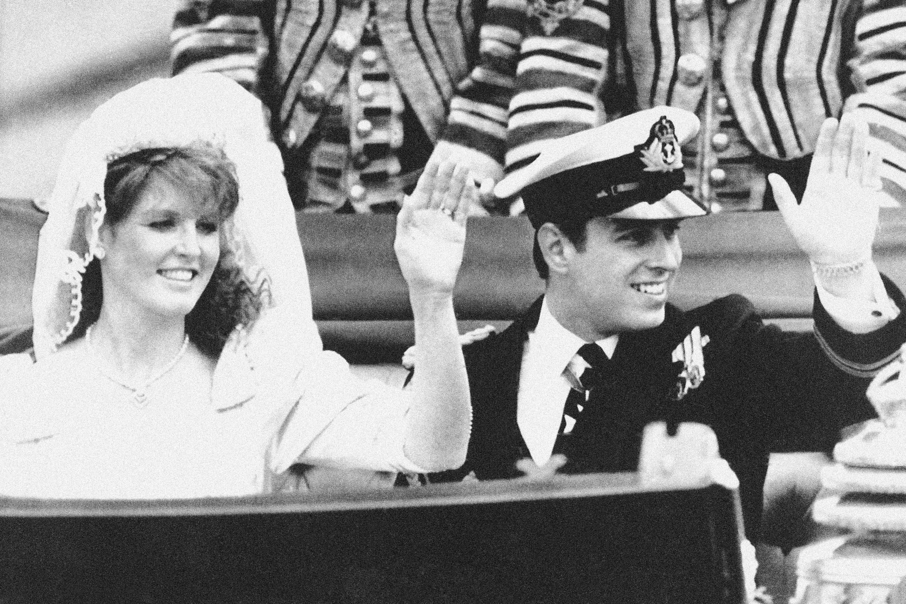 Prince Andrew and his bride Sarah Ferguson wave from a horse drawn State Landau to the waiting crowds as they leave Westminster Abbey in London, July 23, 1986. Photo / AP