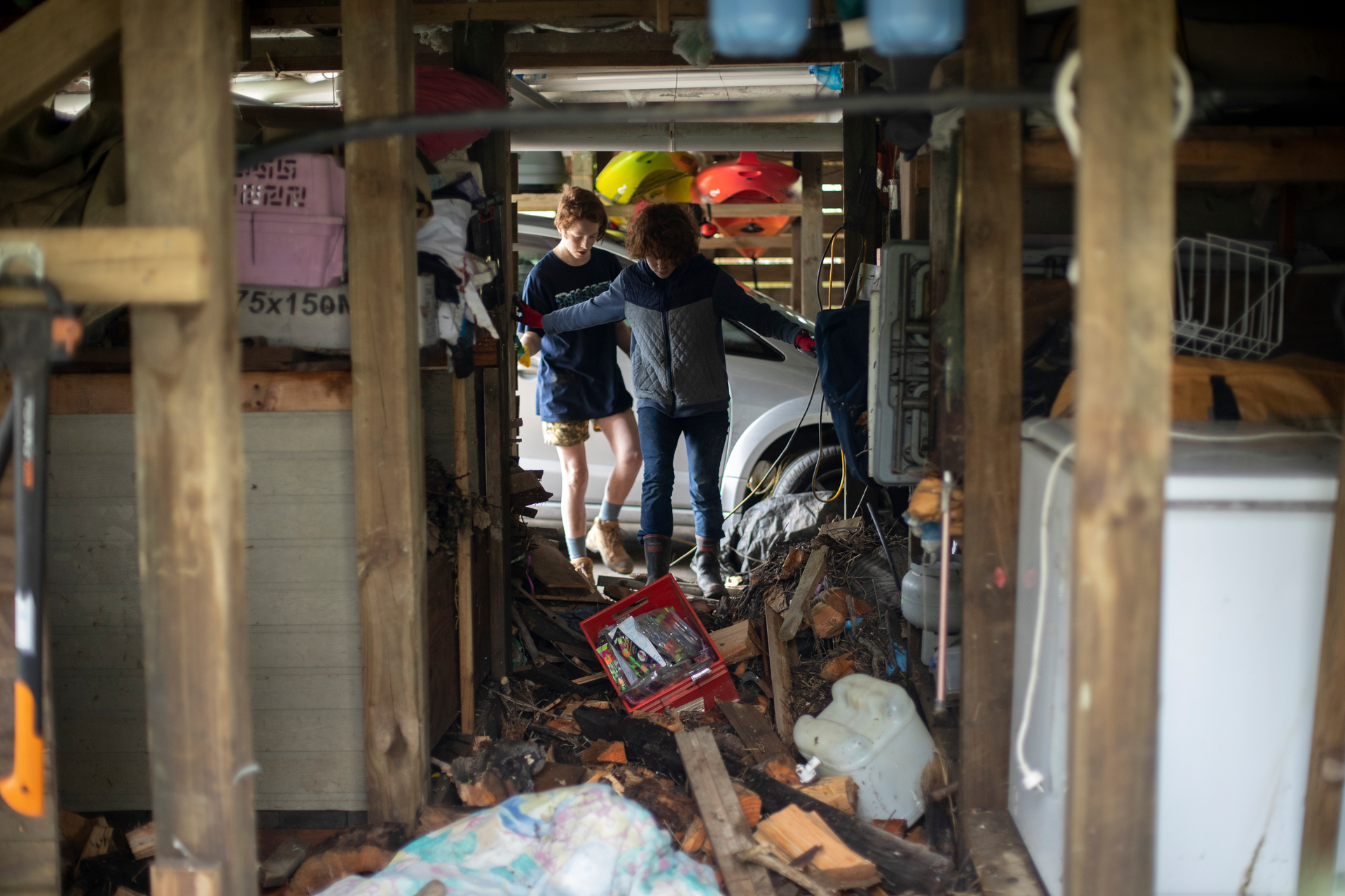 Oscar Springford-Miller, 14, and his sister Beatrice, 11, walk through their flood-damaged basement. Photo / Dean Purcell