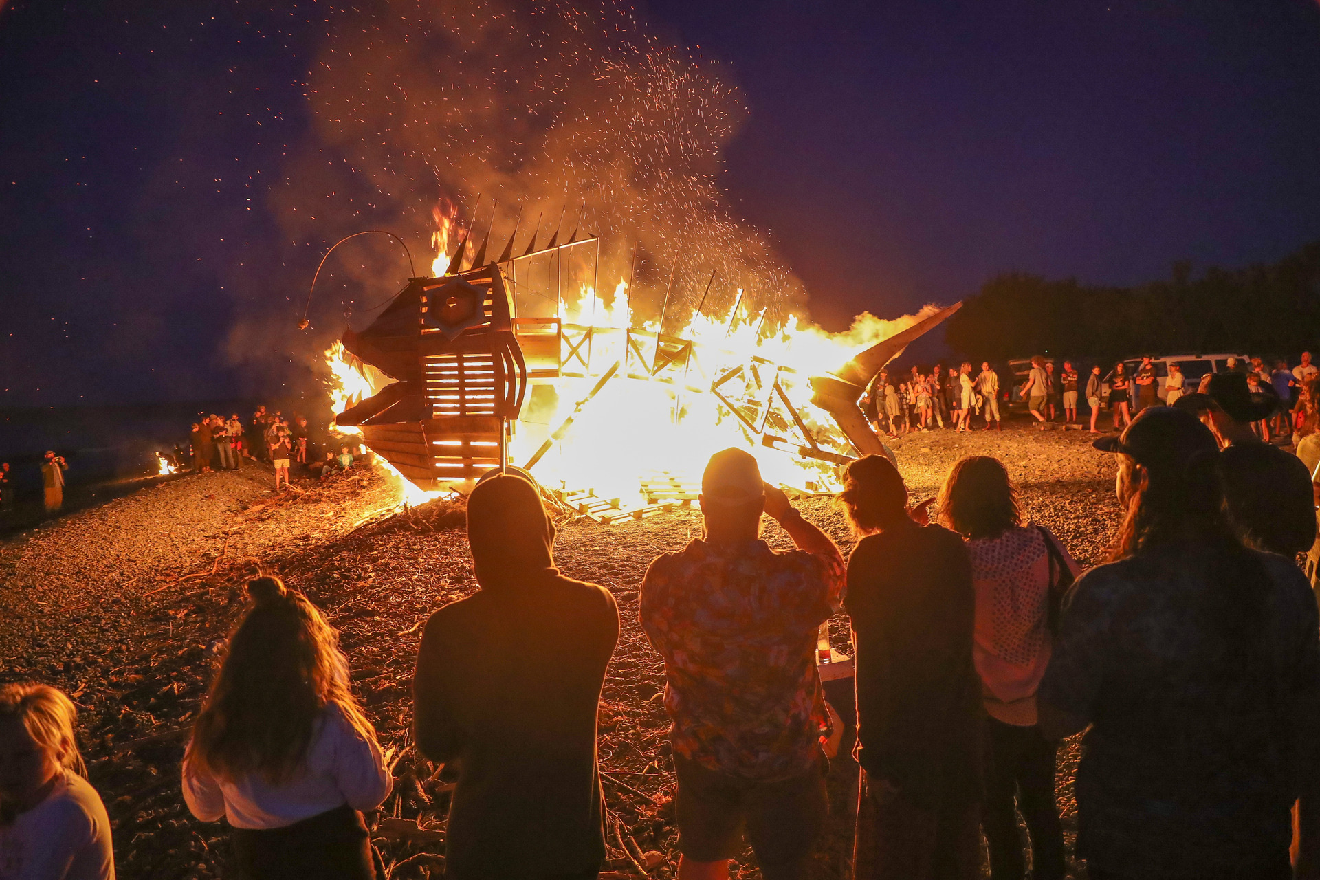 People watch the sculpture burn on the beach. Photo / Warren Buckland