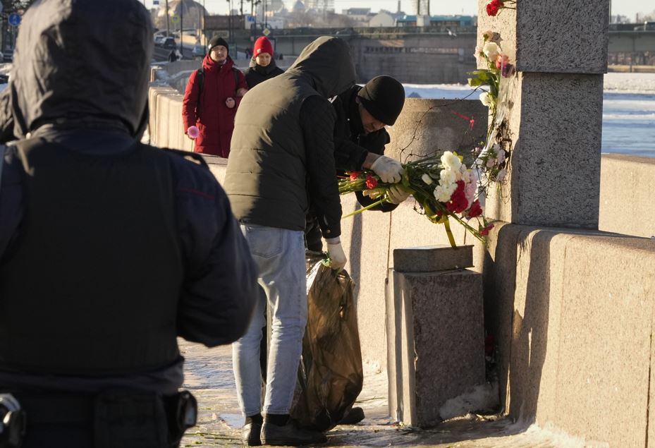 Municipal workers follow the orders of the authorities and take away flowers brought by people paying tribute to Alexei Navalny from the Memorial to Victims of Political Repression in St Petersburg. Photo / AP