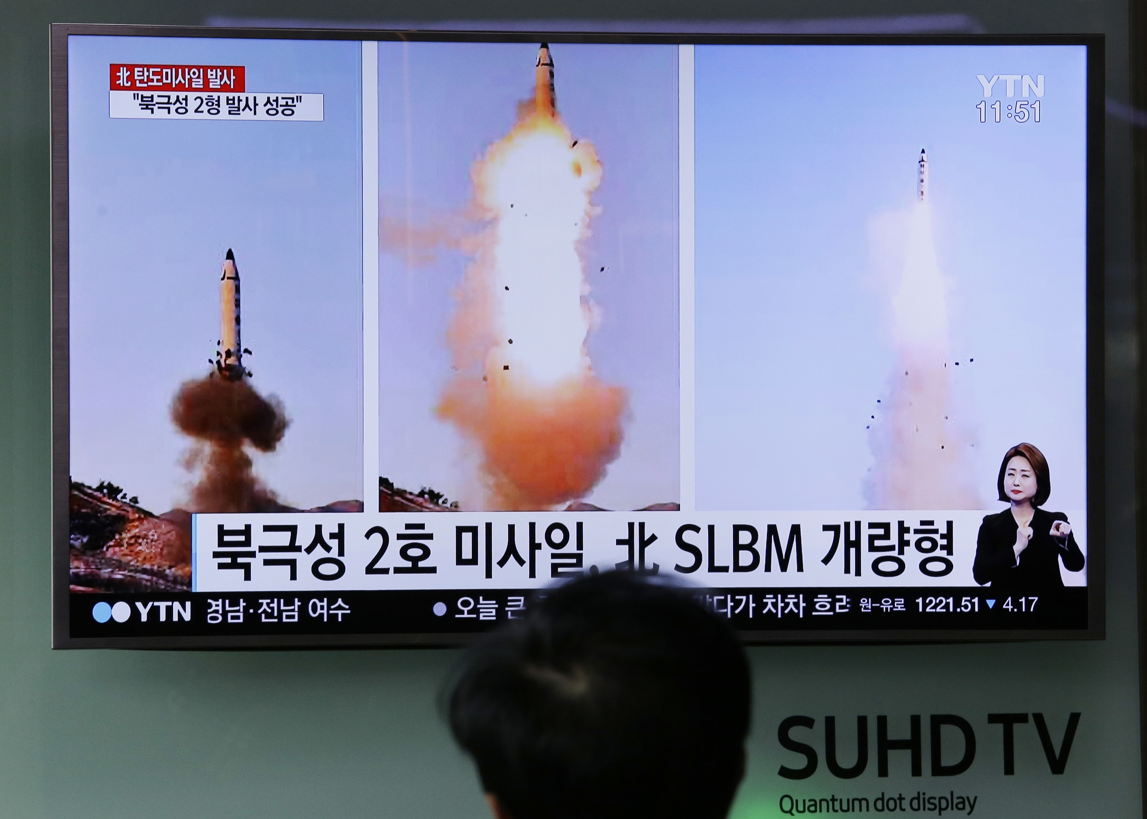 A man watches a TV news program showing photos published in North Korea's Rodong Sinmun newspaper. Photo / AP