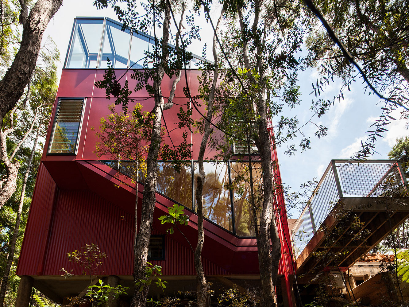 The Red House is is tucked in a thick patch of Waitakere bush. Picture / Simon Devitt