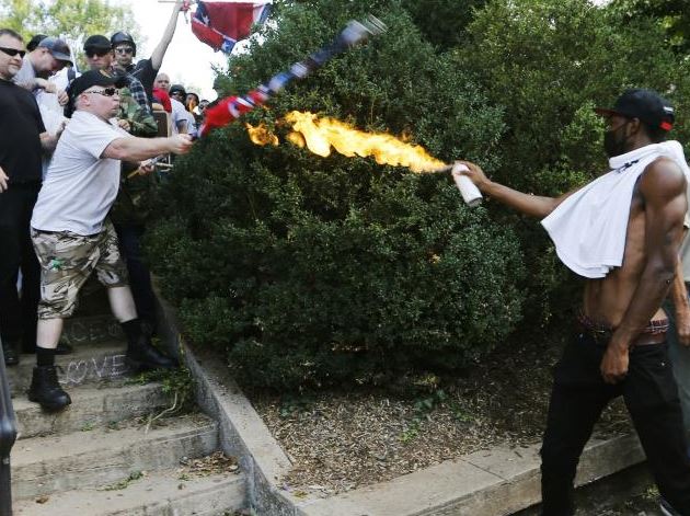 A counter-demonstrator uses a lit spray can against a white nationalist demonstrator. Picture: AP Photo/Steve Helber