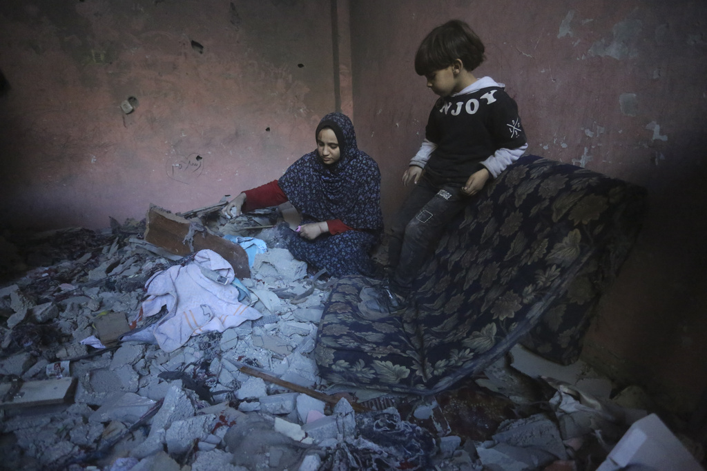 Palestinians salvage their belongings after an Israeli strike in Rafah, Gaza Strip on December 24. Photo / AP