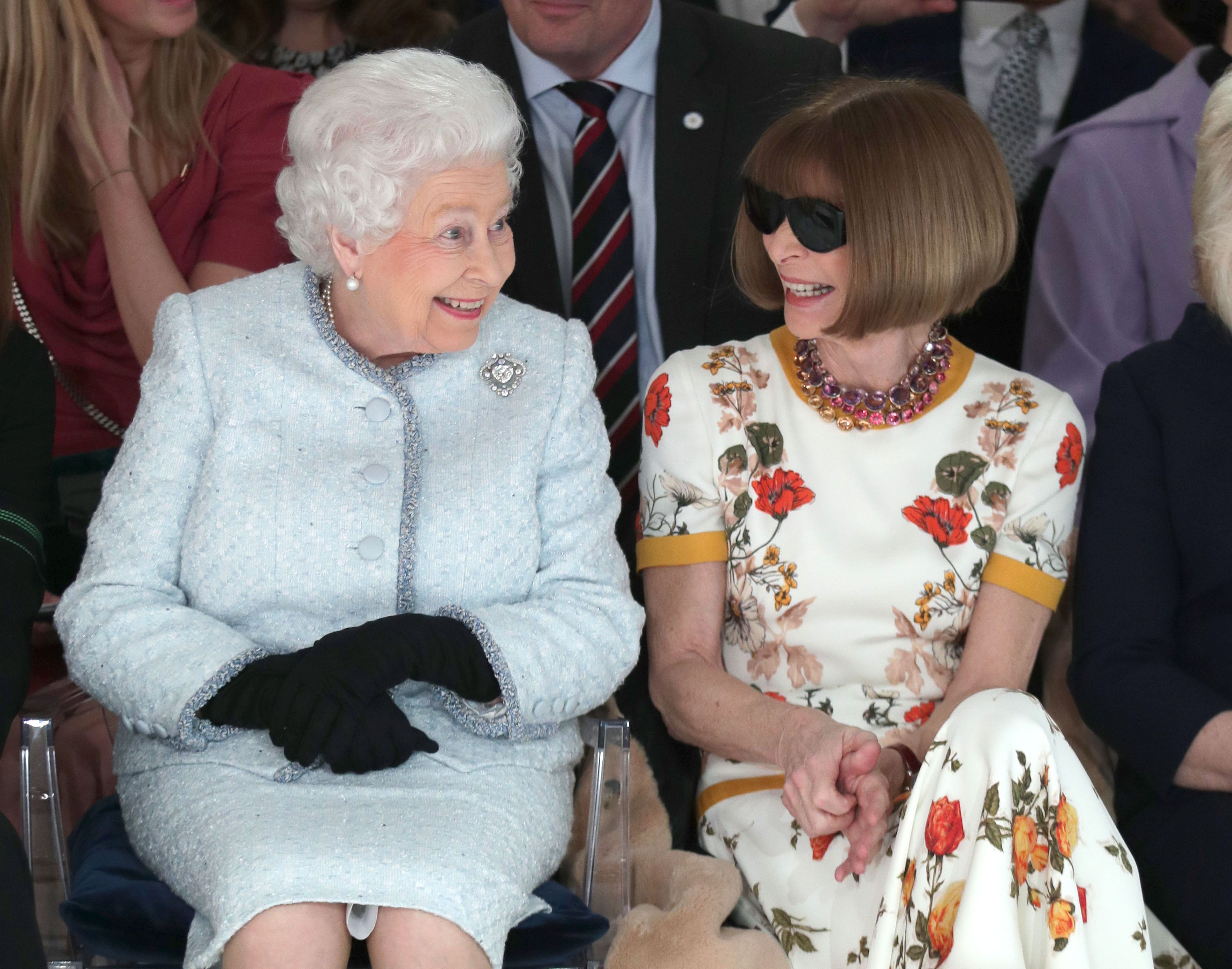 Queen Elizabeth II sits next to Anna Wintour as they view Richard Quinn's runway show before presenting him with the inaugural Queen Elizabeth II Award for British Design as she visits London Fashion Week's BFC Show Space (Photo by Yui Mok - Pool/Getty Images)