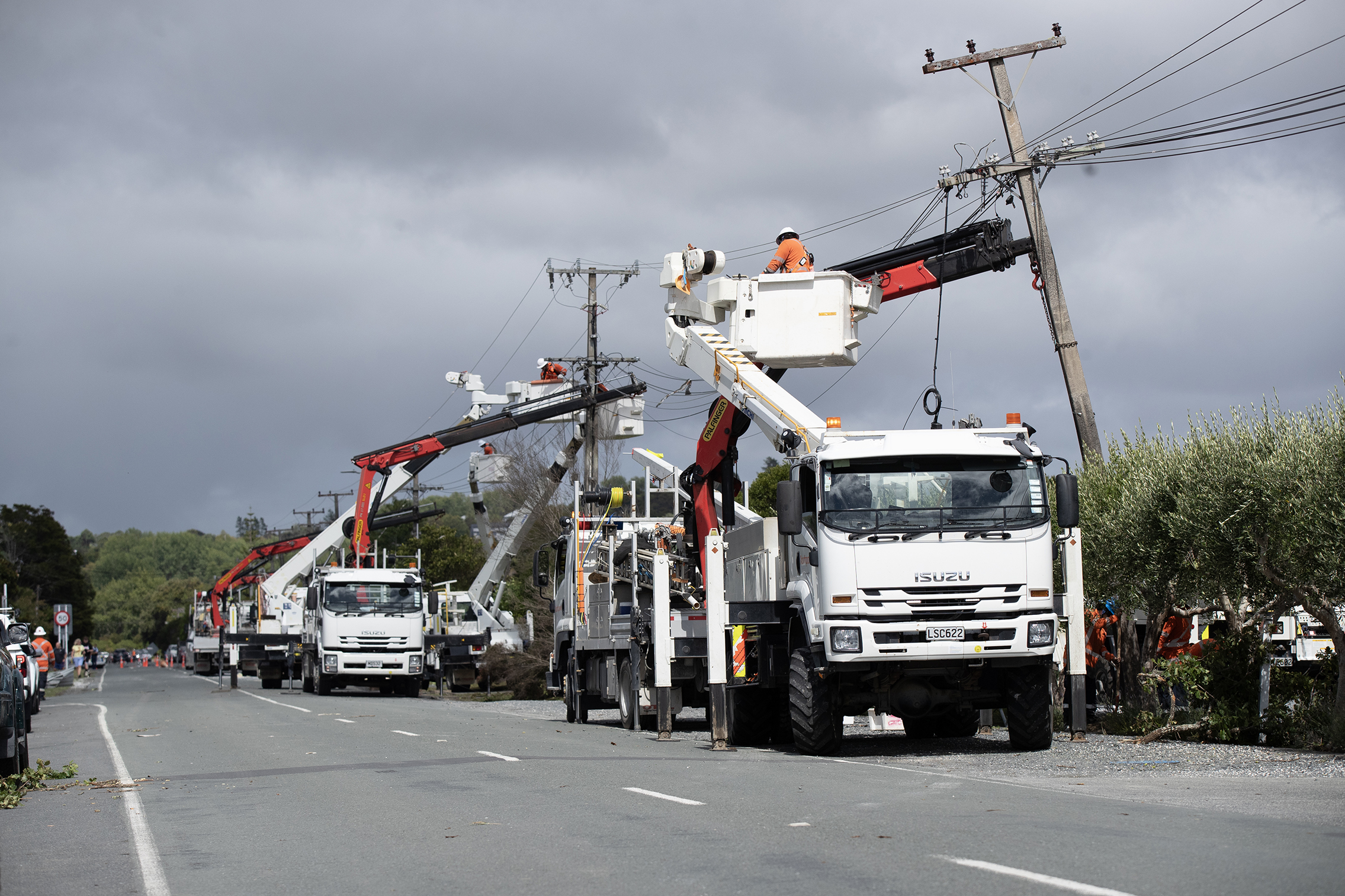 Power companies working in Moir St to restore electricity to Mangawhai village. Photo / Hayden Woodward