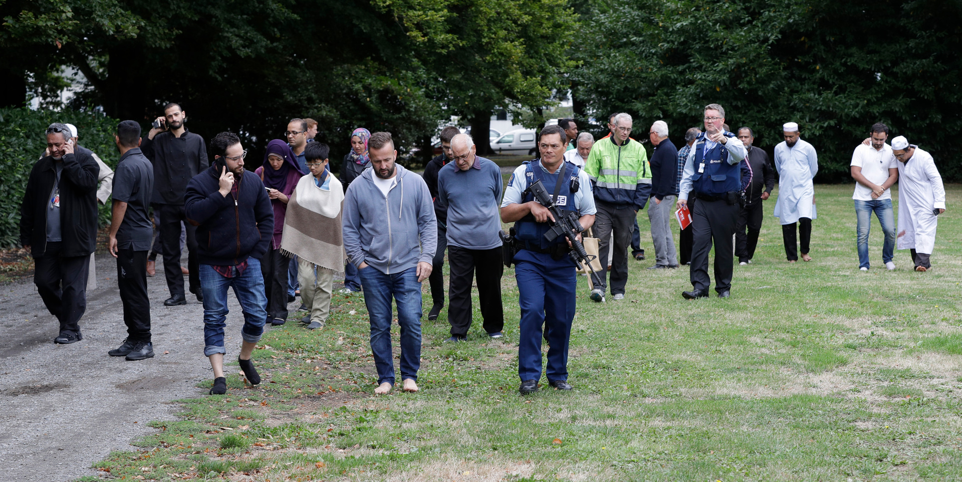 Police escort witnesses away from the mosque in central Christchurch.