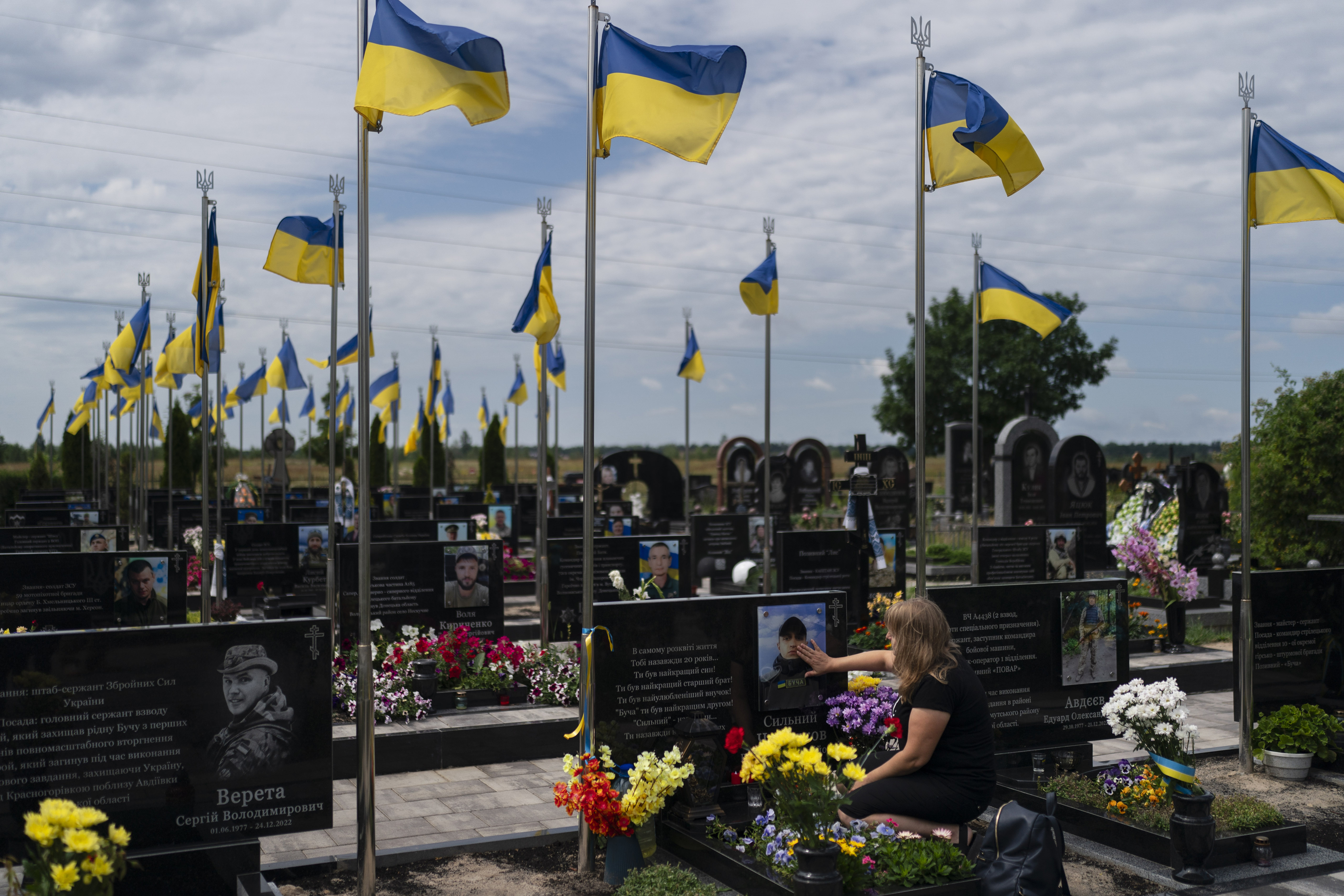 Svitlana, who wished to be identified by her first name only, touches the photo of her son, Vladyslav Cherniakov, at his grave in Bucha, Ukraine. Photo / AP