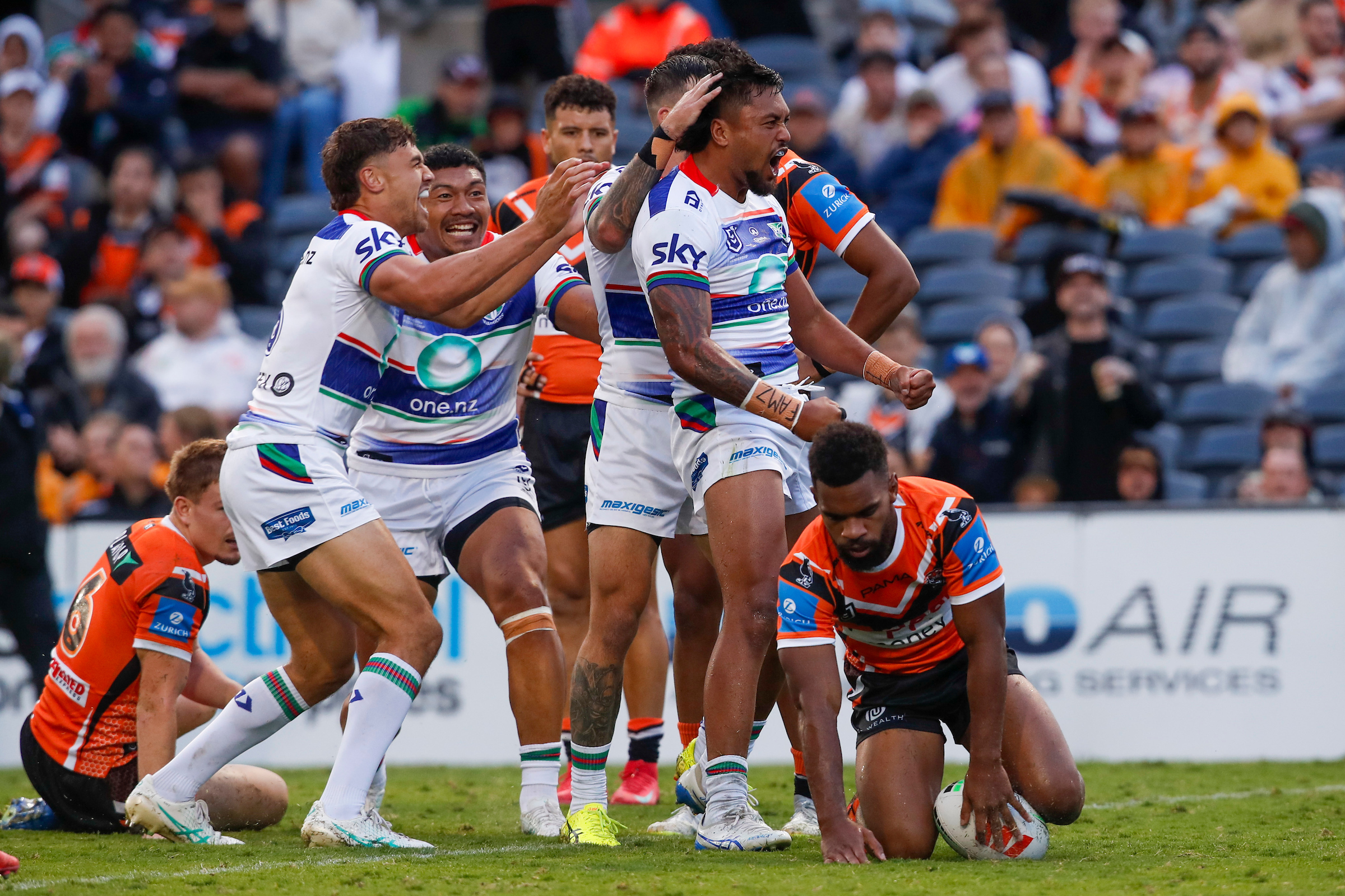 Adam Pompey celebrates with teammates after scoring against Wests Tigers. Photo / Photosport
