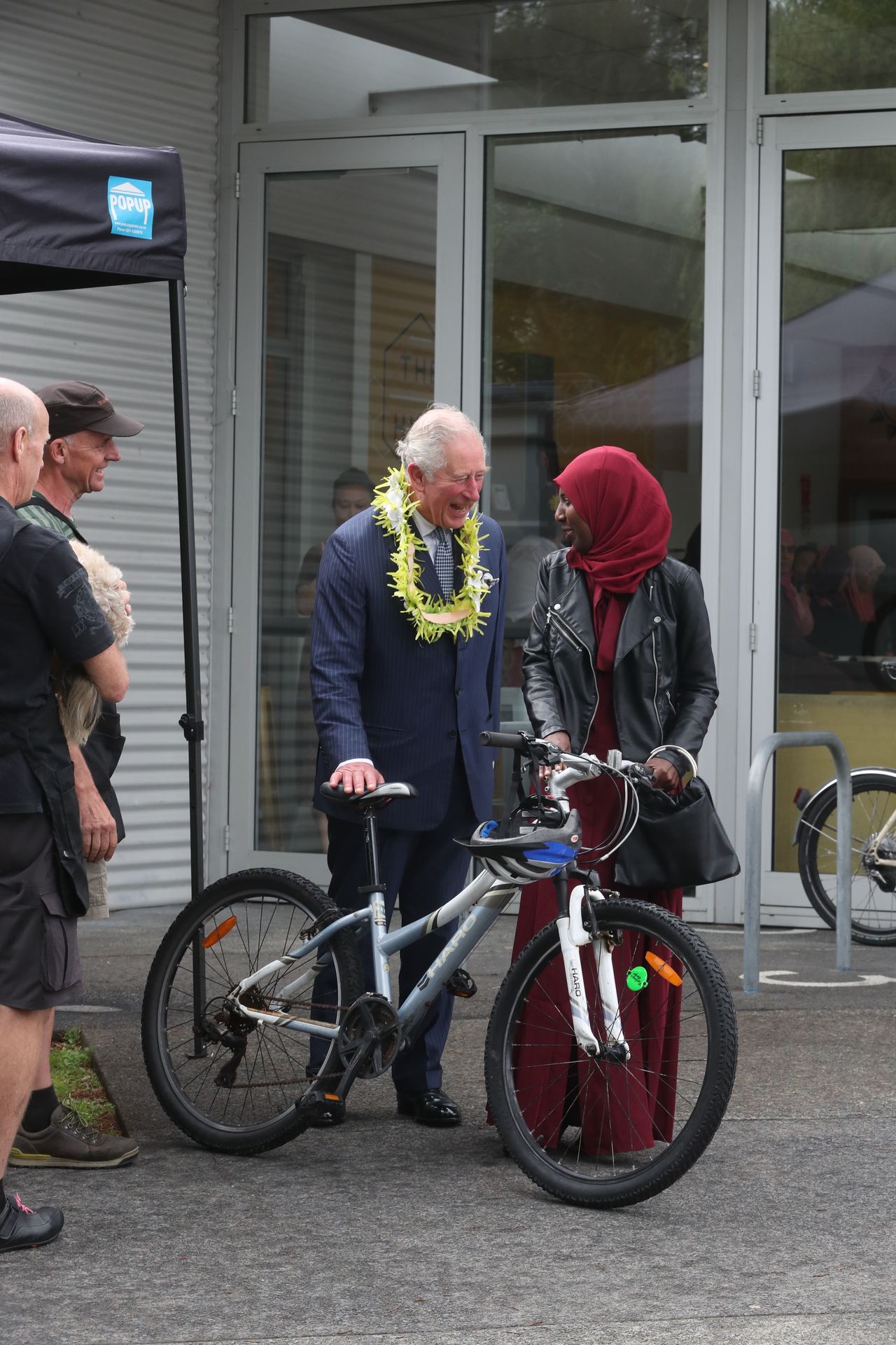 The Prince of Wales presents a bicycle to local refugee woman Amina Shanko during his visit the Wesley Community Centre in Mount Roskill. Photo / Jason Oxenham 
