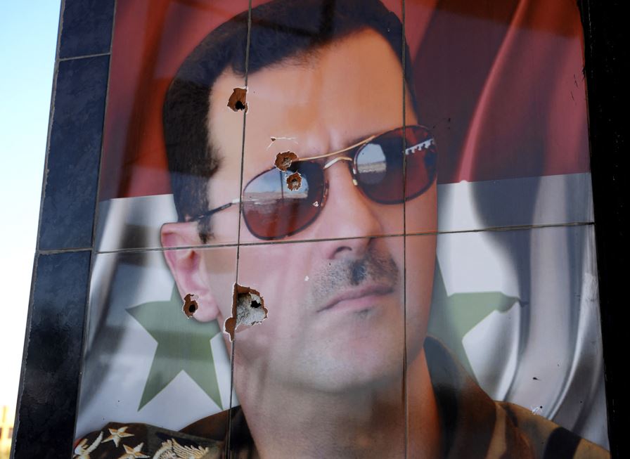 This picture shows a bullet-riddled portrait of Syrian President Bashar al-Assad. Photo / AFP