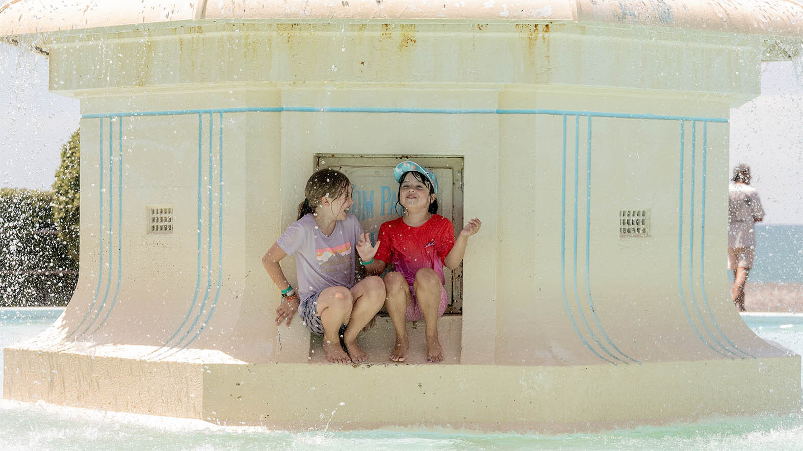 Luka (left) and Indie Peluchetti from Townsville, Australia, play in the Tom Parker fountain to cool down in Napier over the weekend. Photo / Connull Lang