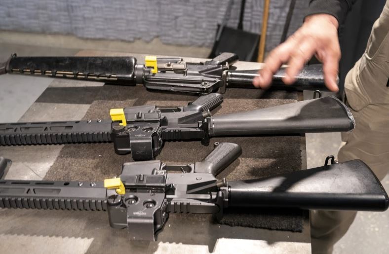 A row of AR-15 style rifles, one with a conversion device installed making it fully automatic, and one a fully automatic M-16 machine gun. (AP Photo/Alex Brandon)