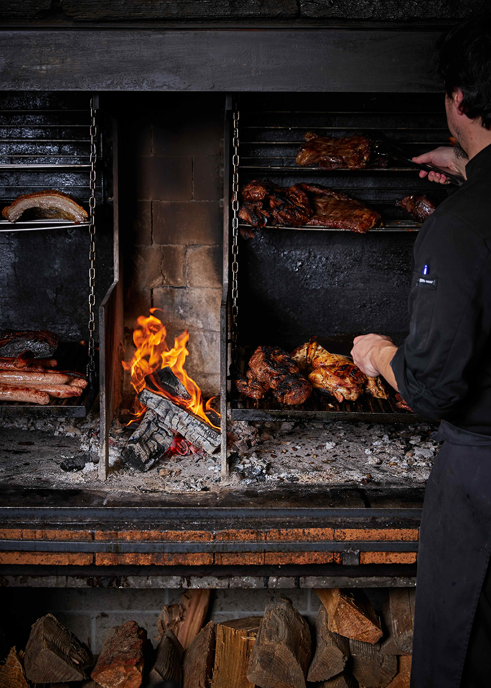 A chef works in the open barbecue kitchen, blistering and charring New Zealand produce.