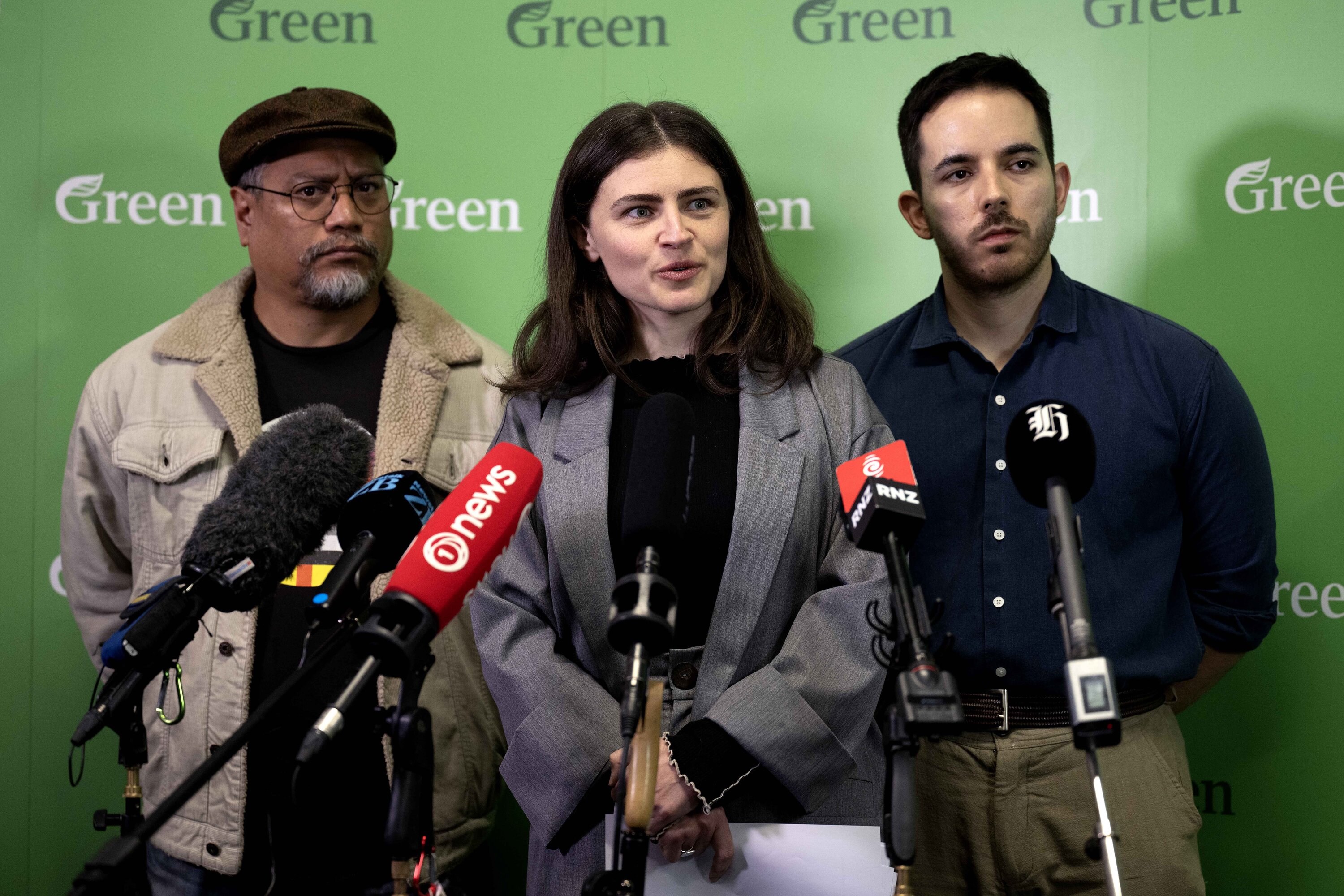 Green Party MPs Teanau Tuiono (left), co-leader Chlöe Swarbrick (centre) and Ricardo Menendez March (right) speak after beginning the process to boot Darleen Tana from Parliament. Photo / Joe Allison