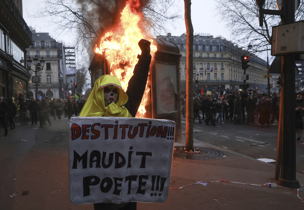 A protester holds a placard that reads