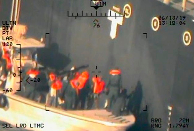 This image shows what the US Navy says are members of the Islamic Revolutionary Guard Corps Navy removing an unexploded limpet mine from the Kokuka Courageous. Photo / AP