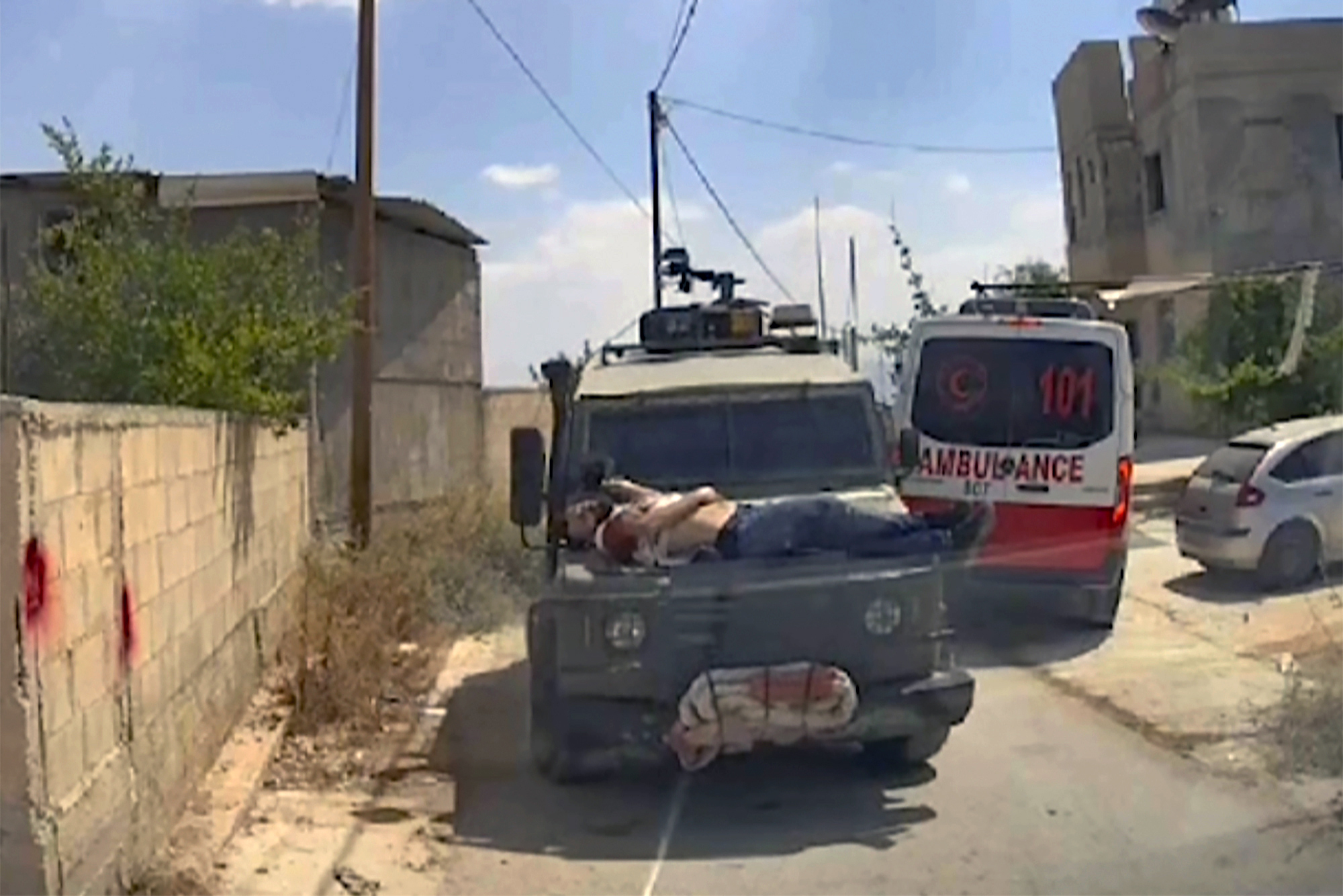 This image made from an ambulance dashboard camera video shows Mujahid Abadi, 24, bleeding from gunshot wounds on top of an Israeli military jeep in the West Bank. Mujahid Abadi survived the attack. Photo / AP