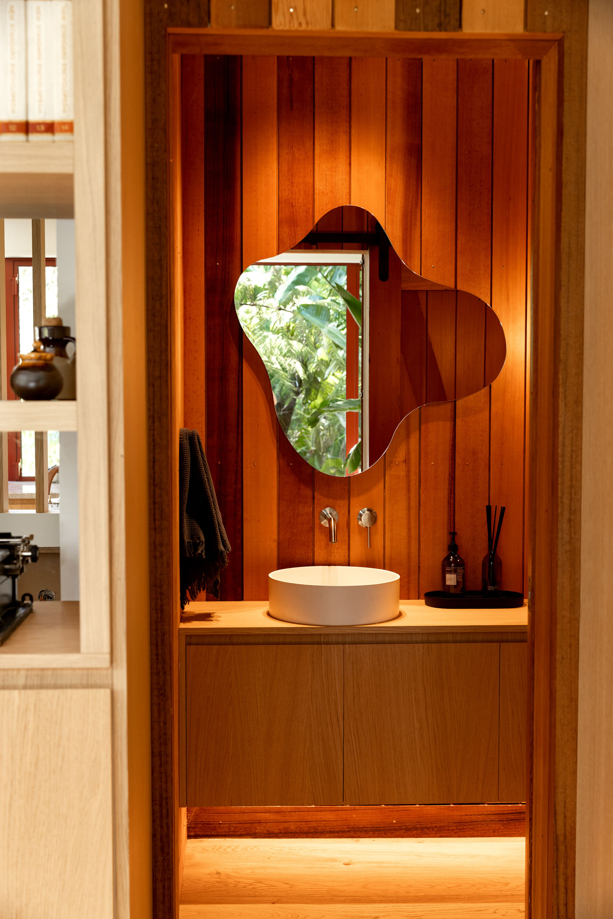 The powder room is hidden away behind a sliding door and oak cabinetry. Photo / Babiche Martens