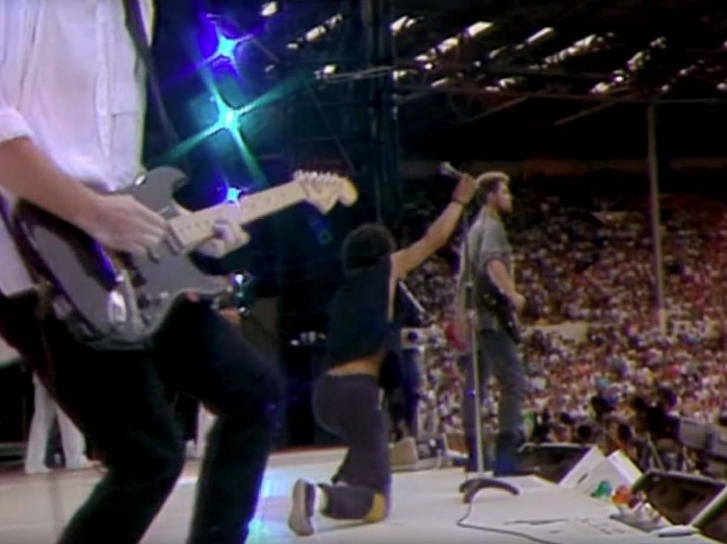 U2 roadie Greg Carroll working onstage during U2's 1985 Live Aid performance at Wembley Stadium.  Photo / YouTube.