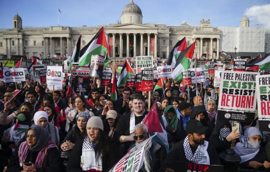 Protesters hold placards and Palestinian flags during a pro-Palestinian rally in Trafalgar Square, London. Photo / AP