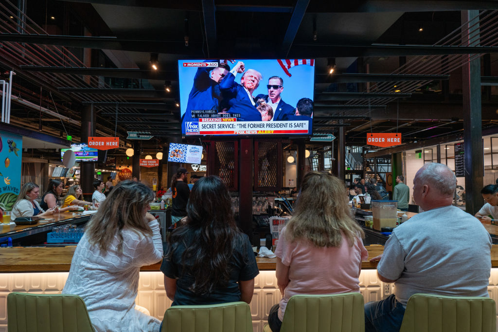 People watch television news at a bar in Milwaukee displaying images from a campaign rally for former US President Donald Trump where he was injured. Photo / Getty Images