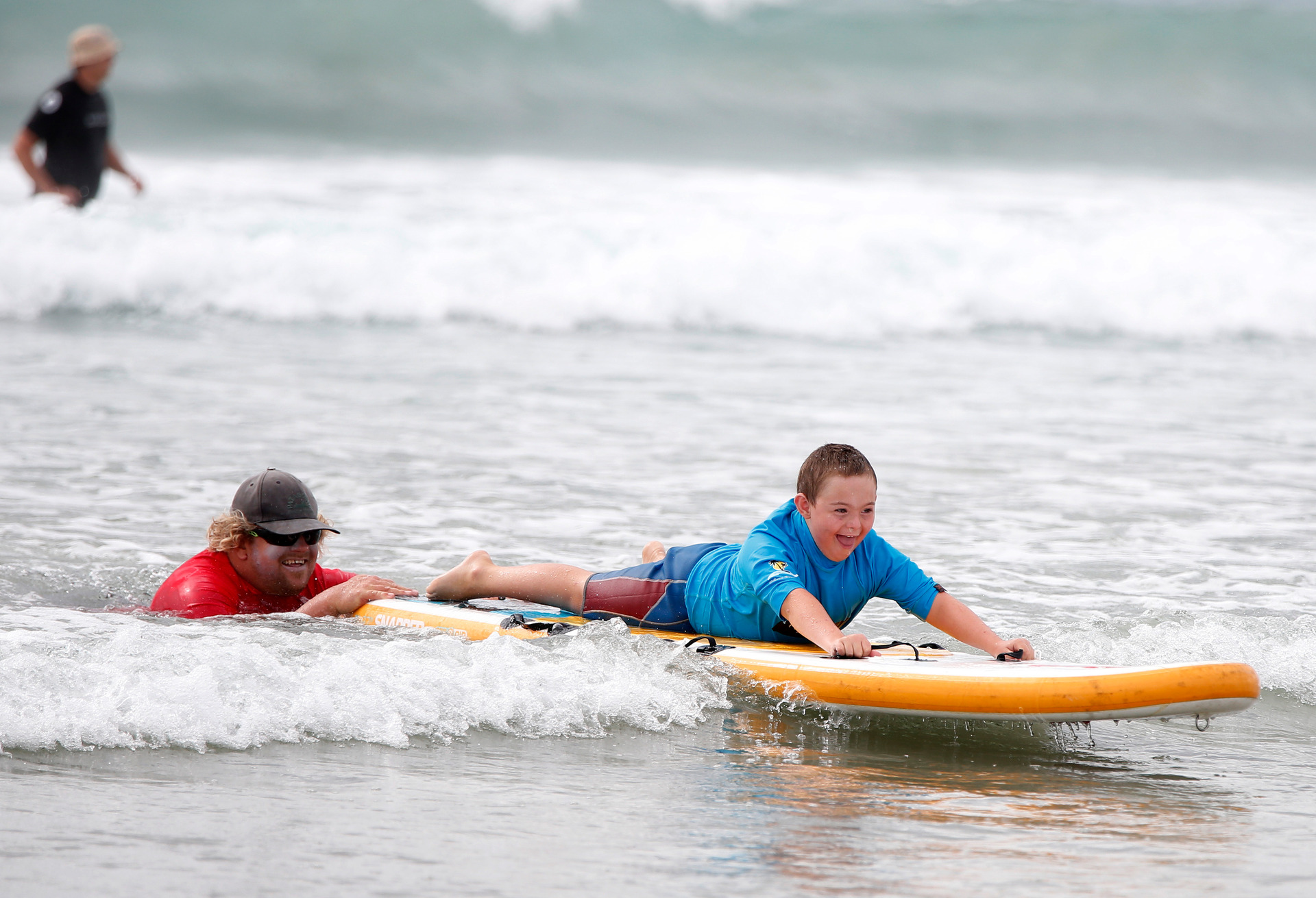 Chevy McIntosh, 10, from Whangārei is helped by volunteer and surf instructor Grae Snelling from Waipū.