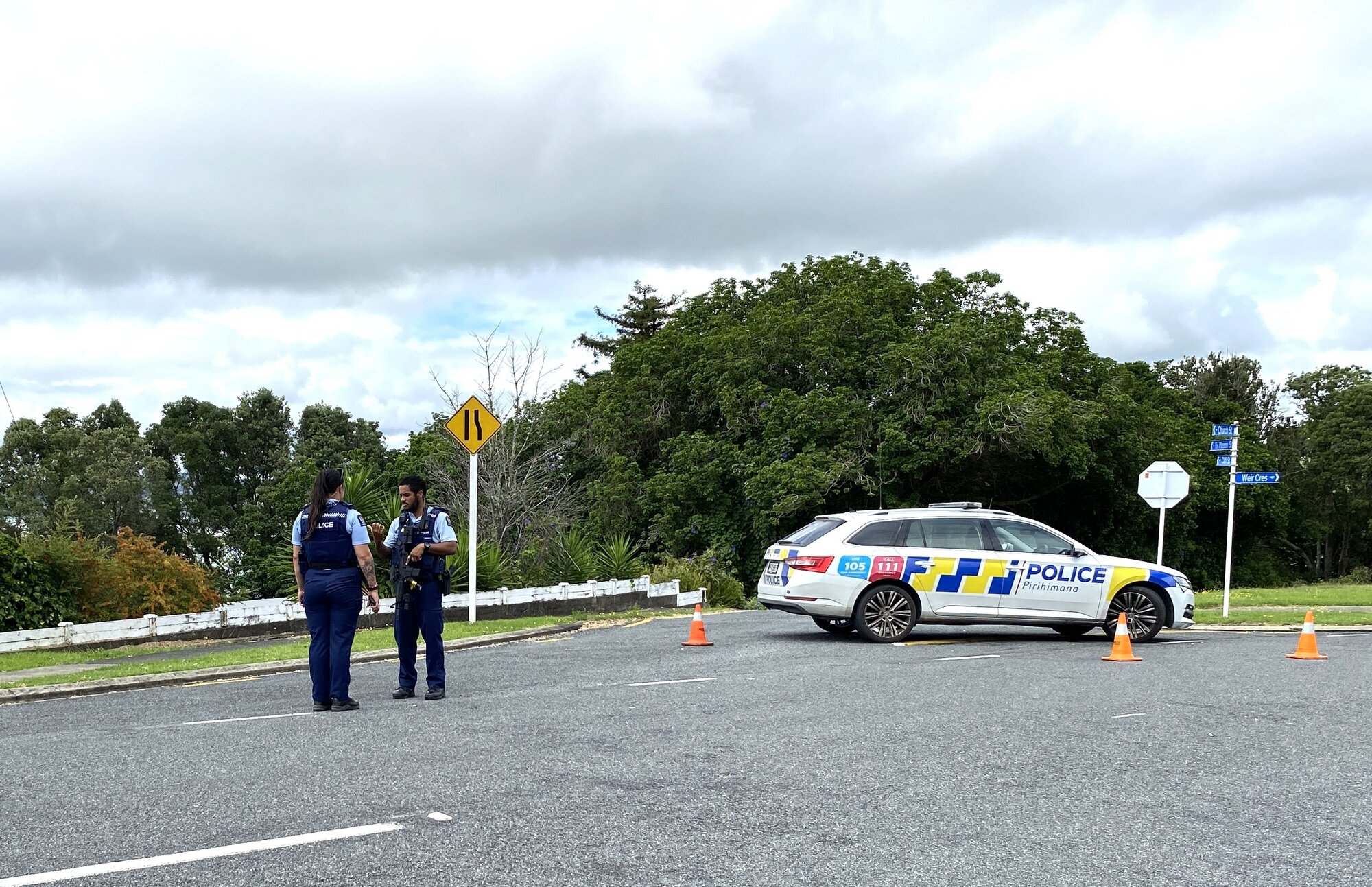 Police officers, some armed, helped with the cordons in Onerahi, stopping people to ask if they had heard or seen anything. Photo / Denise Piper