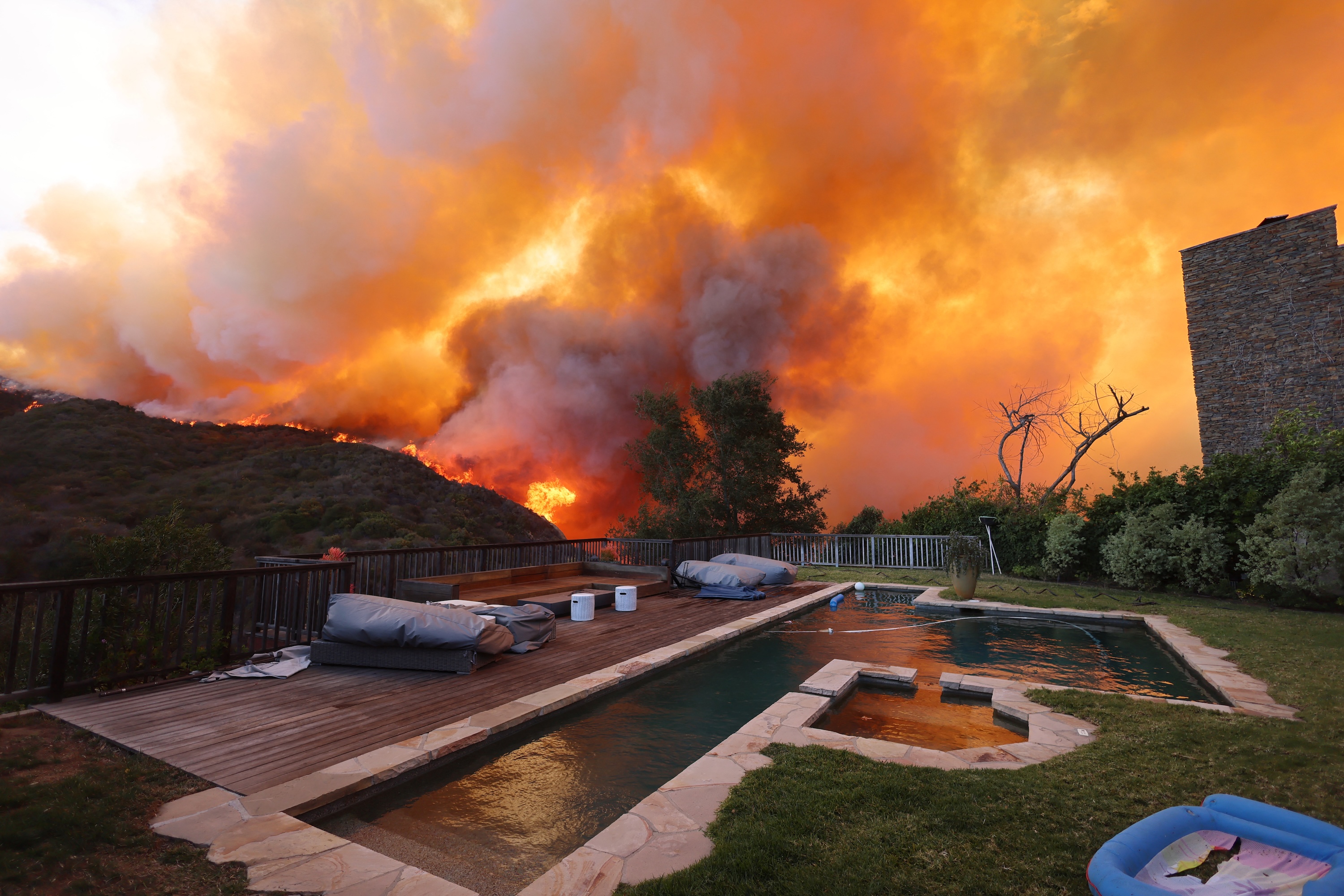 A wildfire burns near homes in Pacific Palisades, California. Photo / AFP