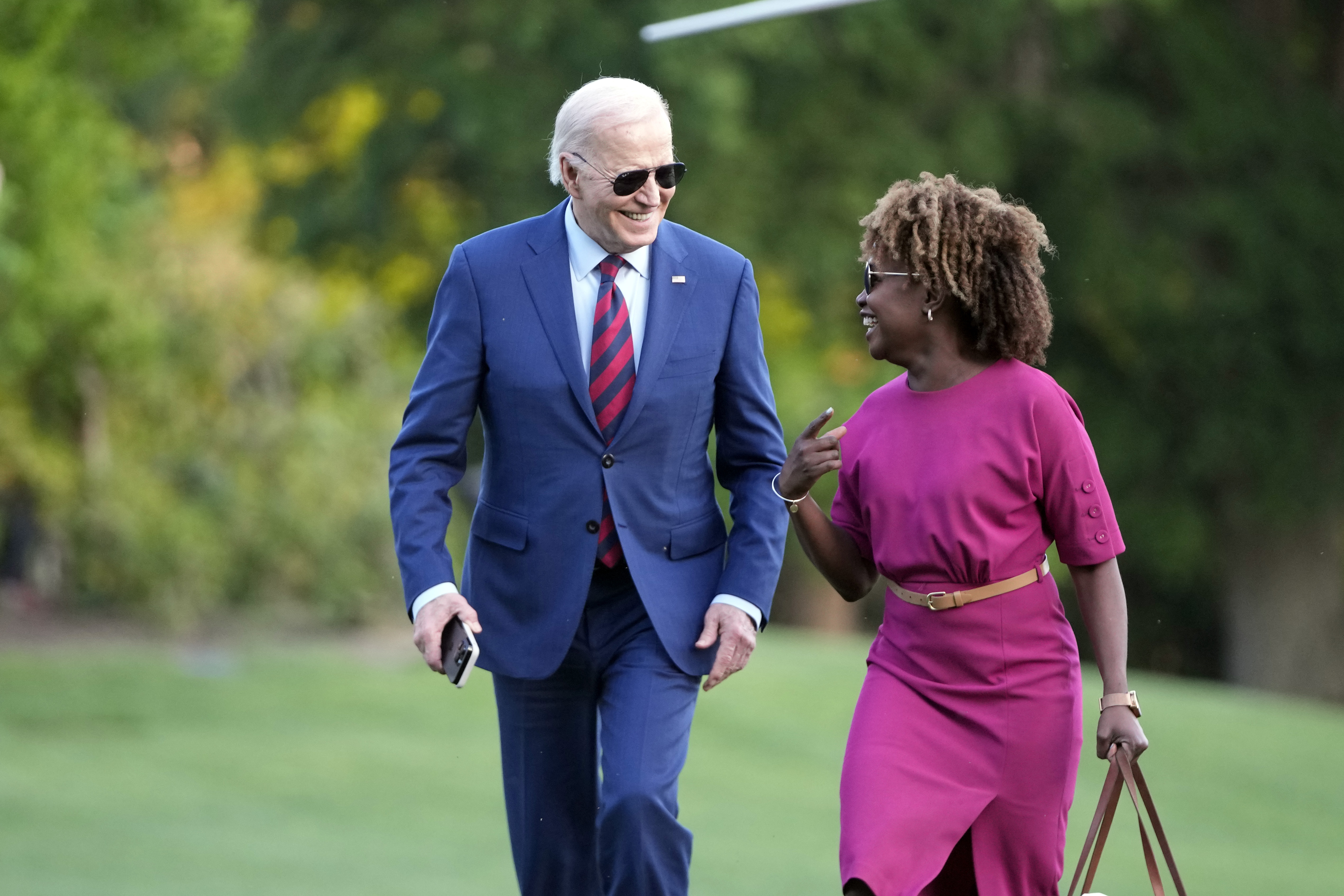 President Joe Biden walks across the South Lawn of the White House as he talks with White House press secretary Karine Jean-Pierre. Photo / AP