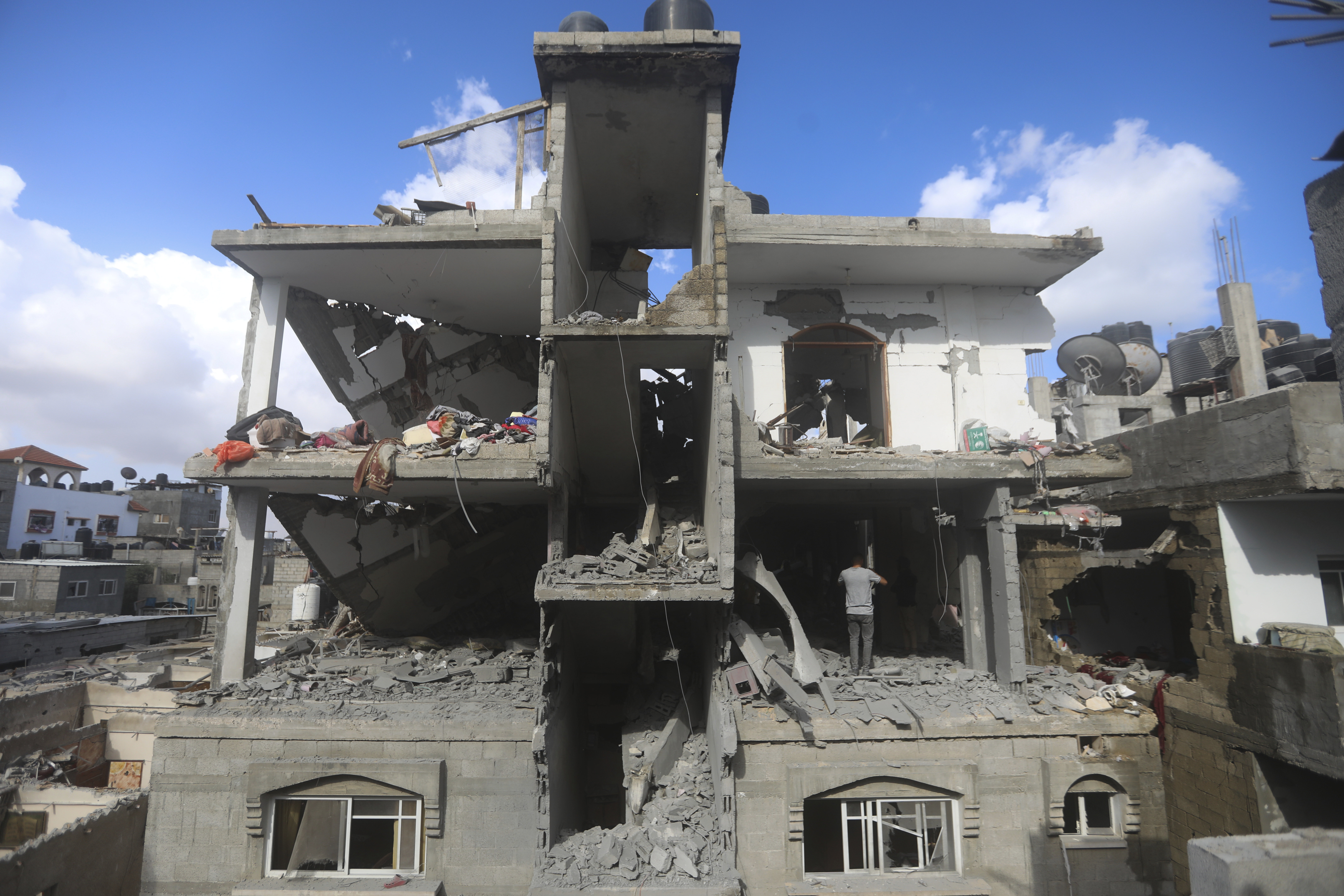 Palestinians look at the destruction after an Israeli strike  in Rafah, Gaza Strip. Photo / AP
