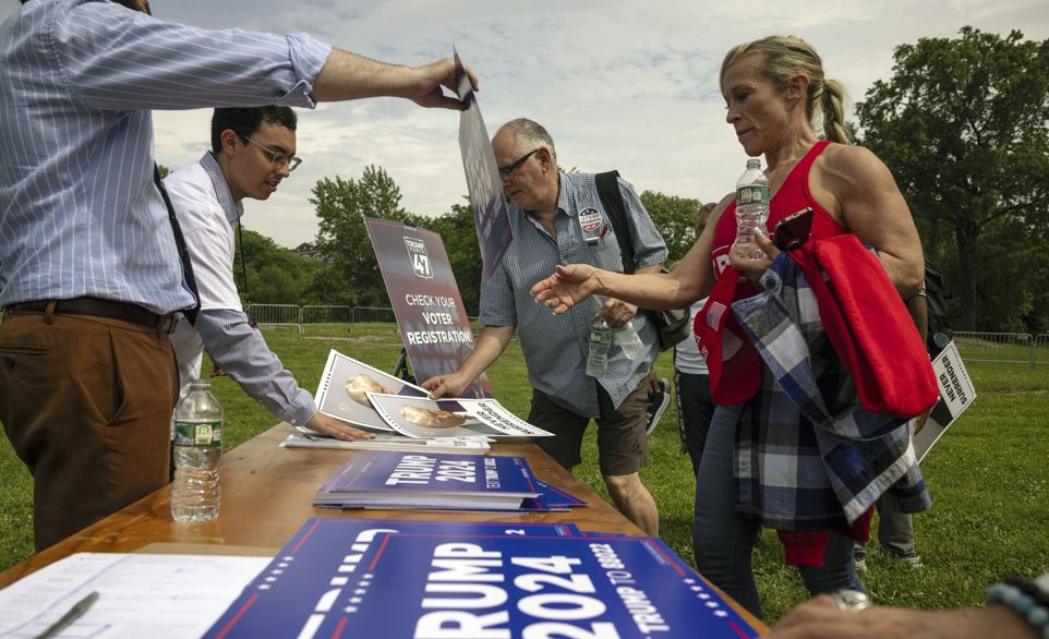 Donald Trump supporters pick up posters before a campaign rally in the Bronx borough of New York. Photo / AP