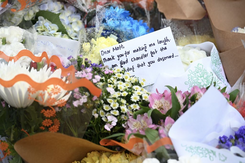 People have placed flowers and notes in front of the building known as the