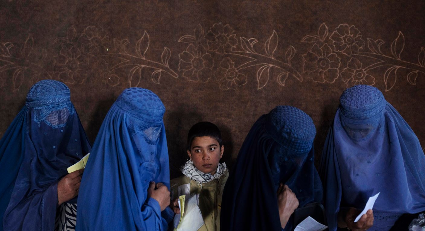 Afghan women wait to receive cash at a money distribution point organised by the World Food Program. Photo / AP