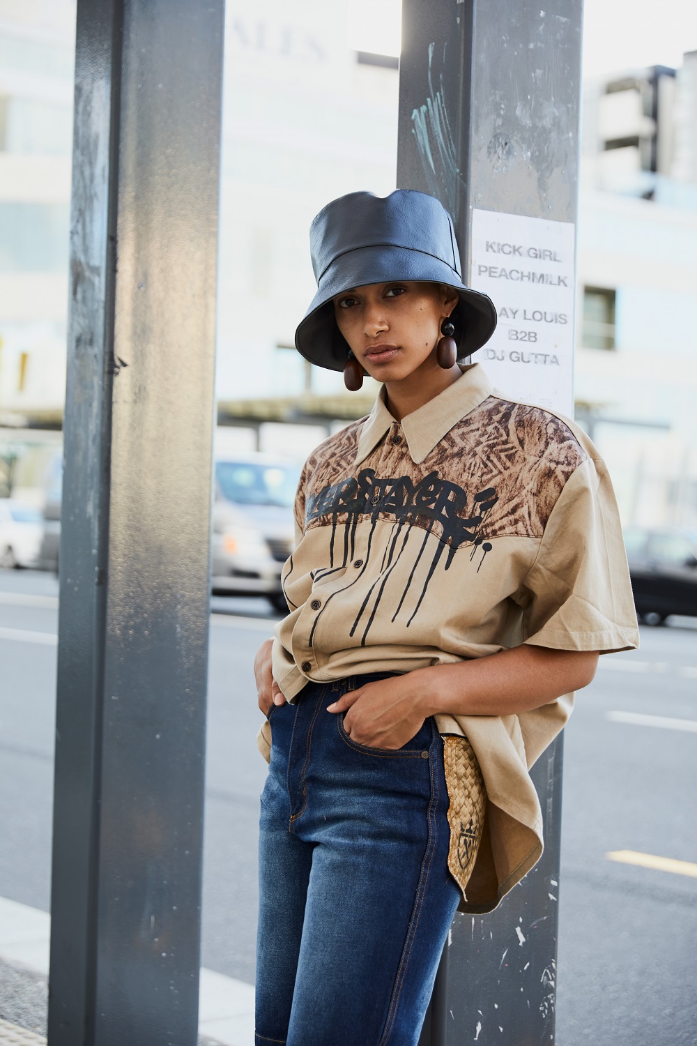 STREET SMARTS: Layla wears Overstayer printed shirt and denim shorts (2003).  Te Kohu by Misty Ratima bucket hat (2018). Zelda Murray wood and perspex earrings (2018). Photo / Mara Sommer