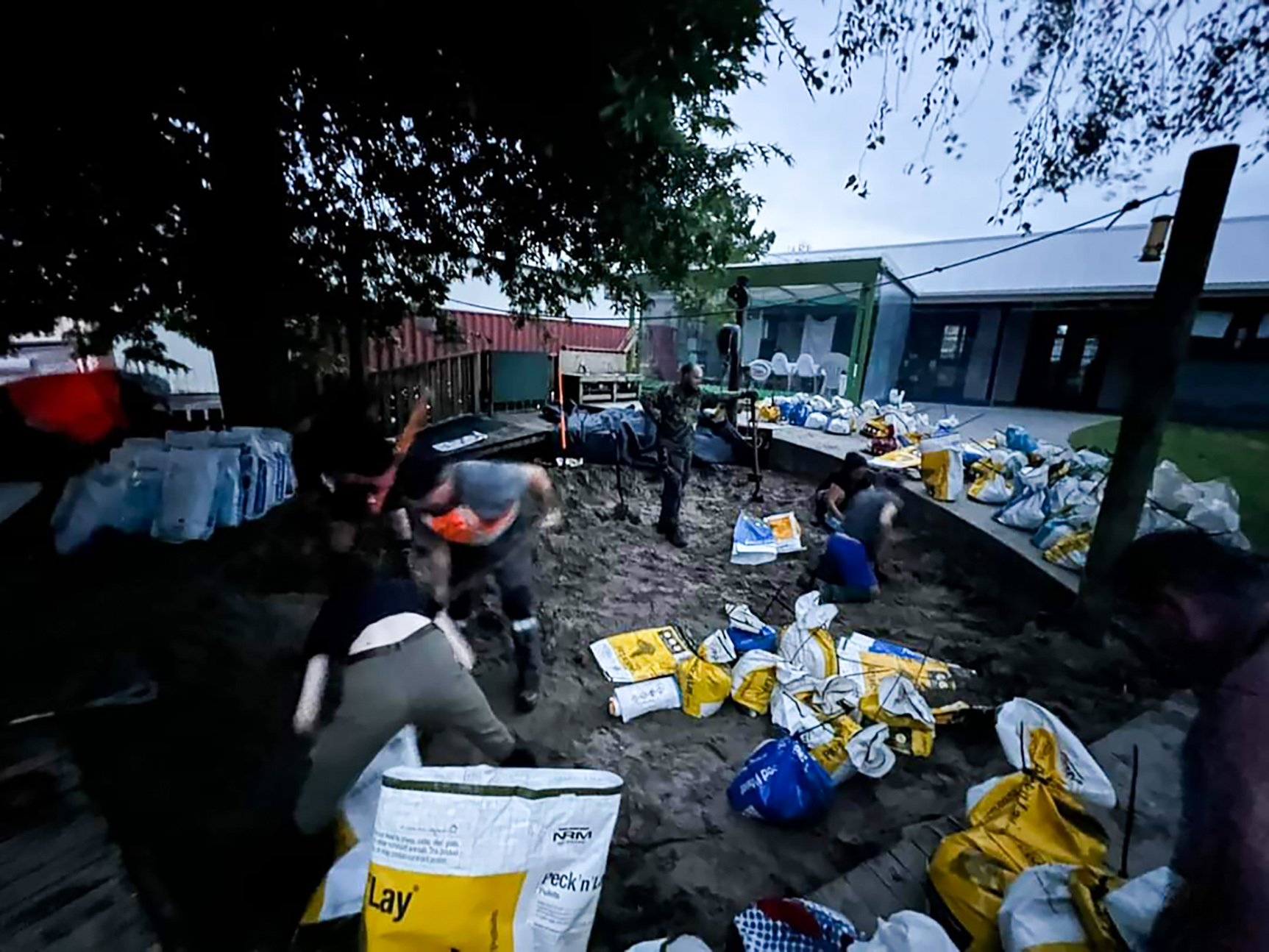 Volunteers make up sandbags from the sandpit at the Kumeū Playcentre in West Auckland ahead of the January floods.