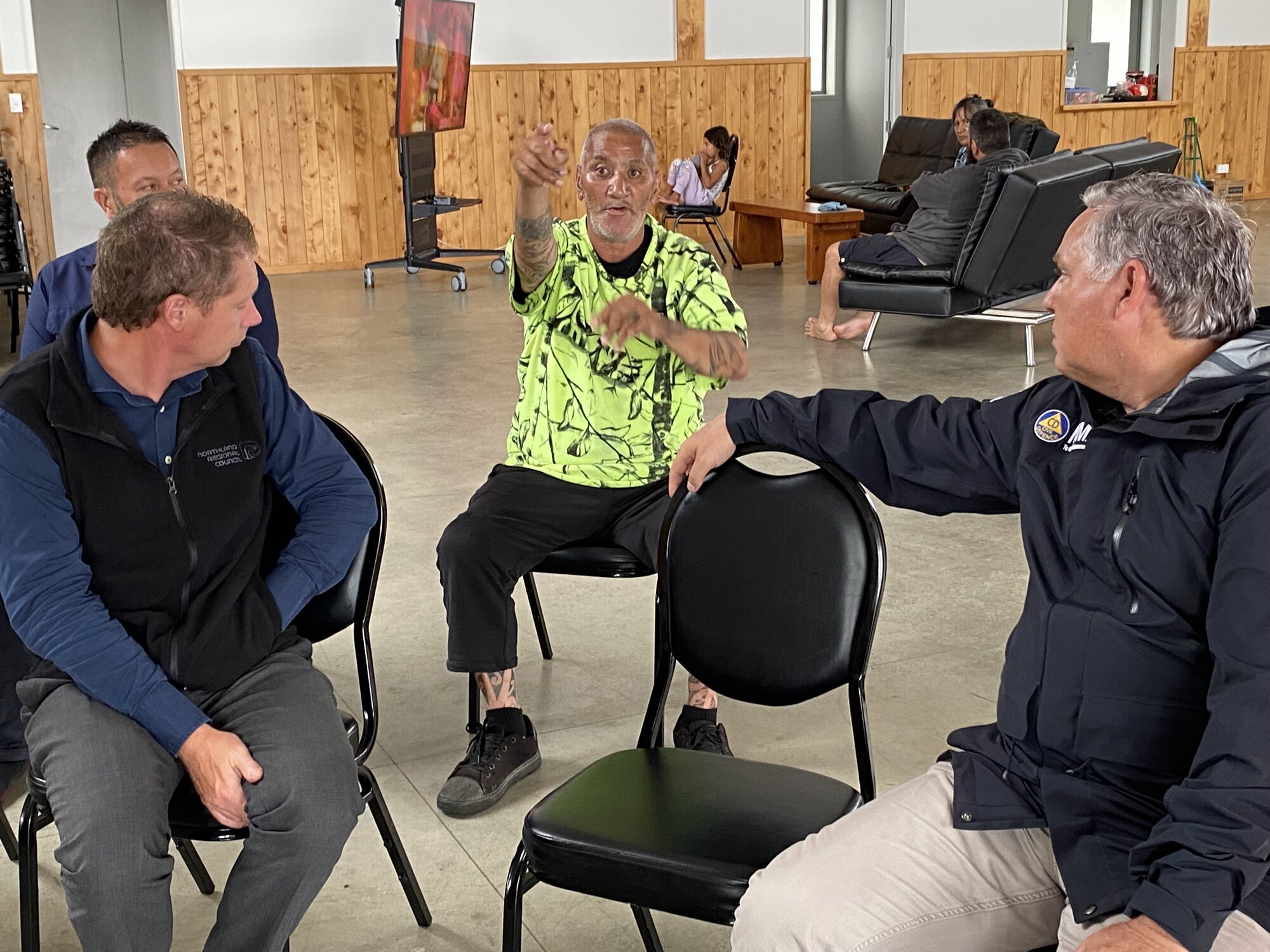 Pattinson Wetere tells his family rescue story to Emergency Minister Mark Mitchell (right) and others during a visit to Mōkau Marae on Tuesday. Photo / Susan Botting 

