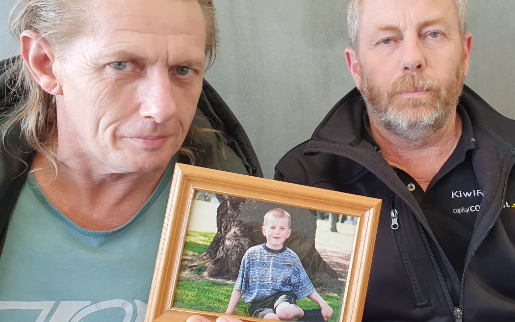 Mark Ginders, left, with a photo of his son Jake when he was younger, and Jake's uncle Wayne Ginders. Photo / RNZ / Phil Pennington