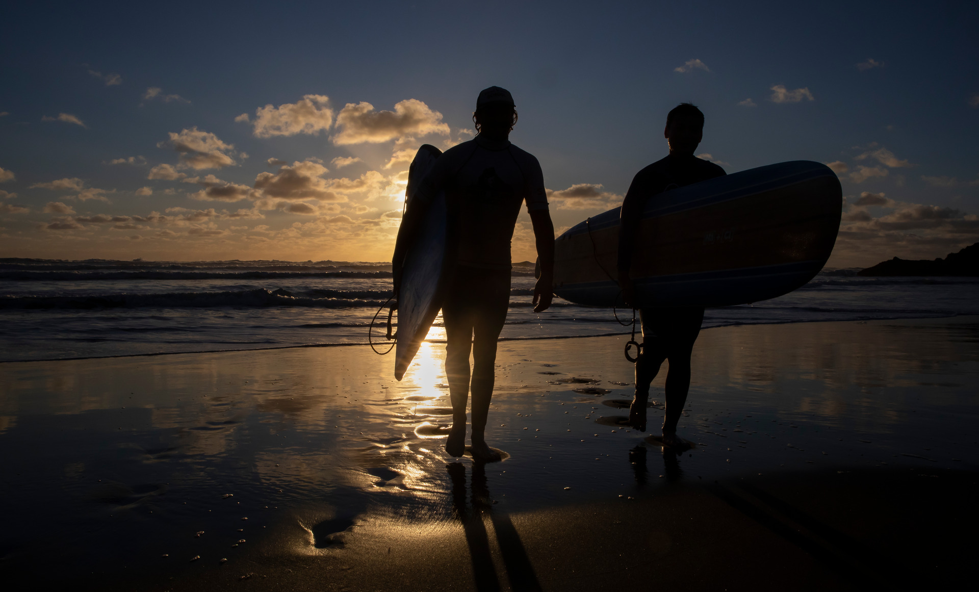 A couple of surfers enjoy the moment at Piha Beach as the sun goes down on a beautiful Auckland day. New Zealand Herald photo by Peter Meecham.