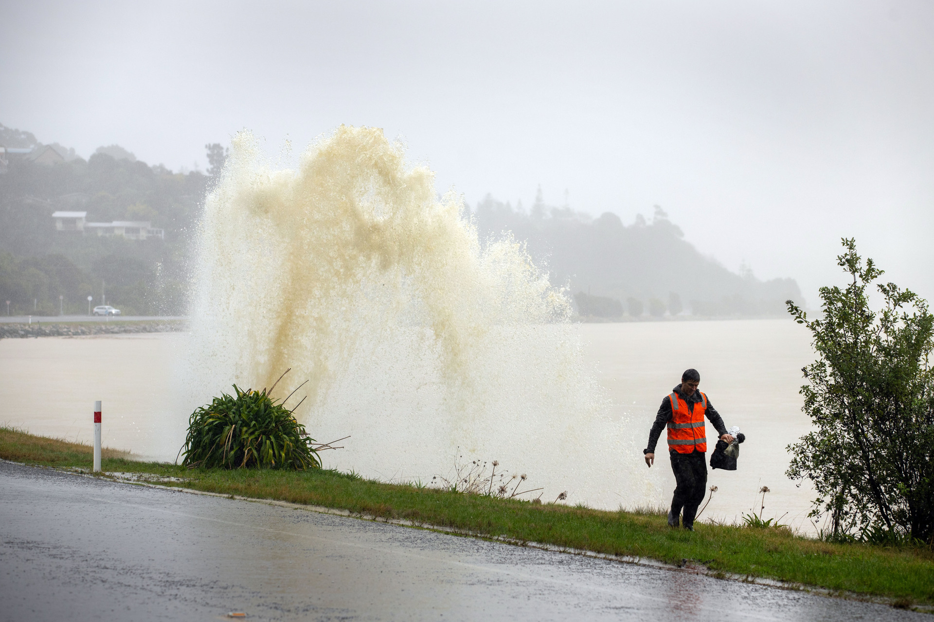 A Nelson resident walks by a broken stormwater pipe during a flood-making rain event on August 18. Photo / Tim Cuff