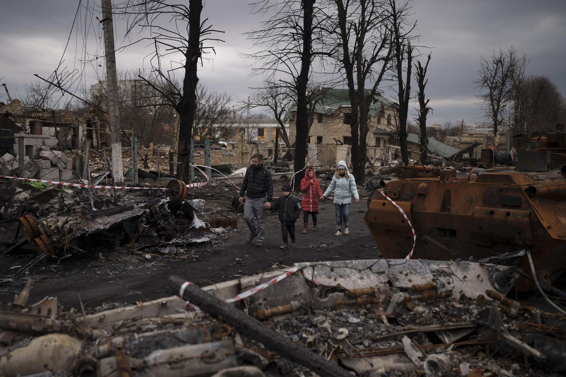 FILE - A family walks amid destroyed Russian tanks in Bucha, on the outskirts of Kyiv, Ukraine, Wednesday, April 6, 2022. Photo / AP