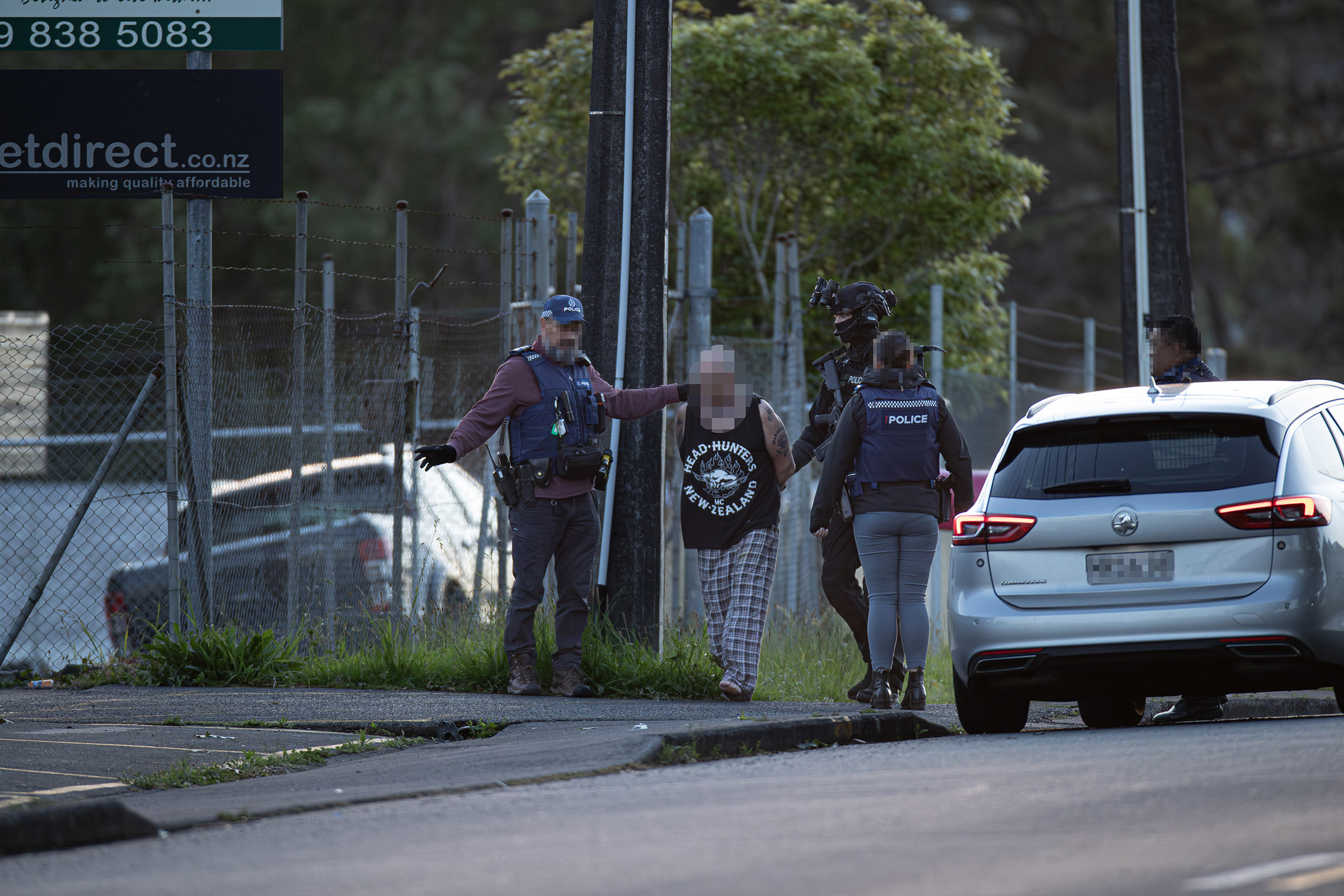 Photos from the scene show patched members being led out of the pad in pyjamas and handcuffs. Photo / NZ Herald